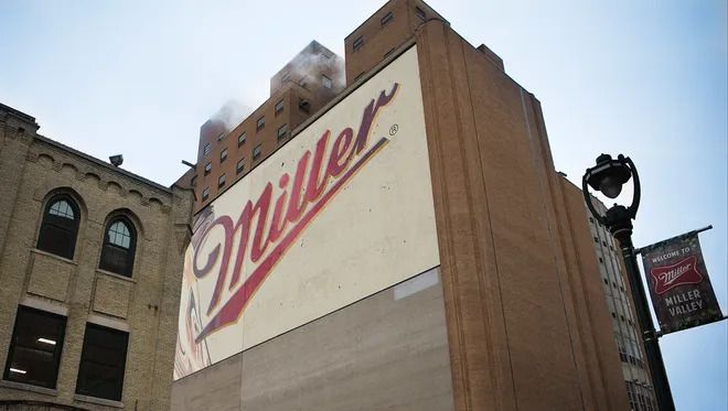 A large miller beer sign is on the side of a building