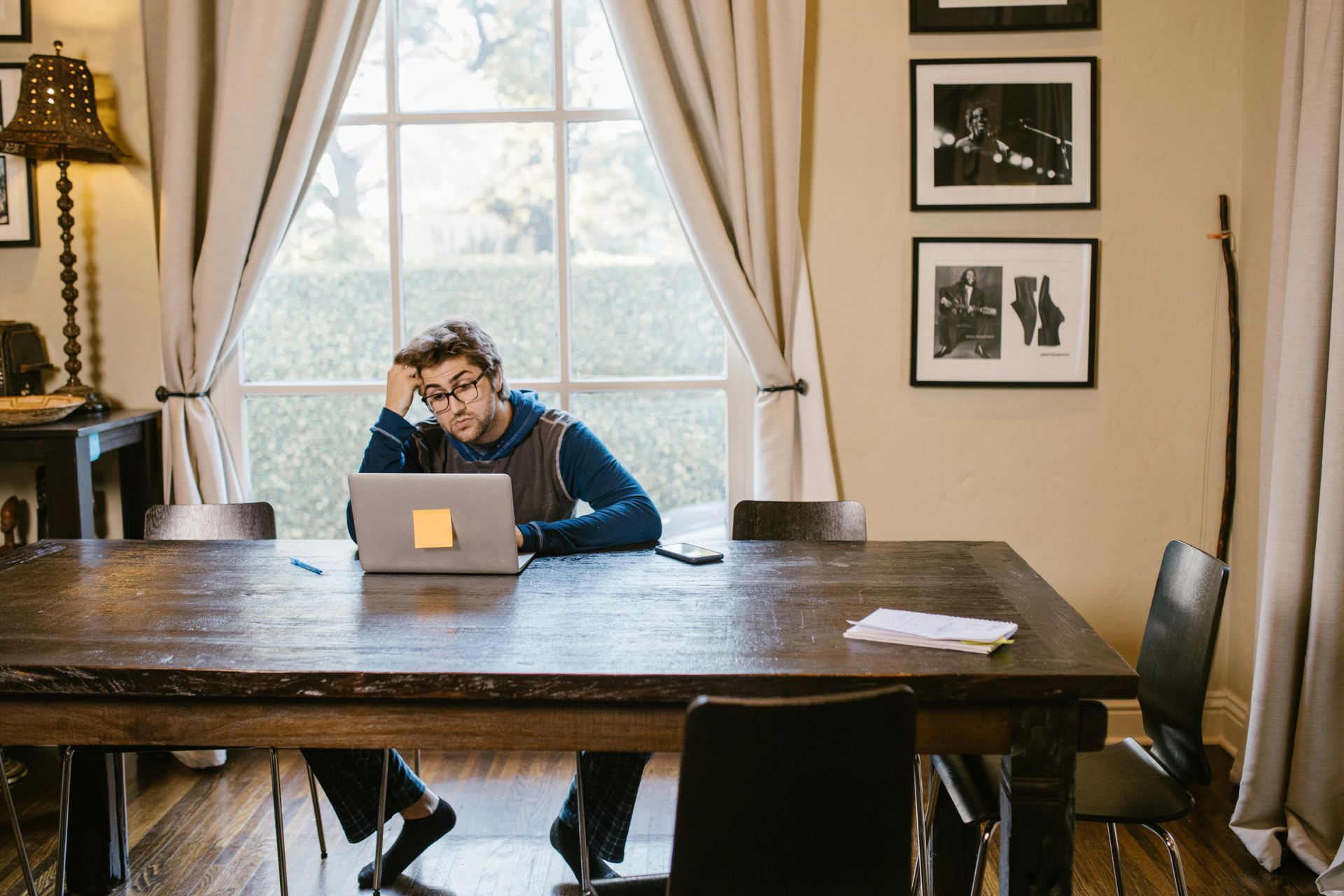 A man is sitting at a table using a laptop computer.