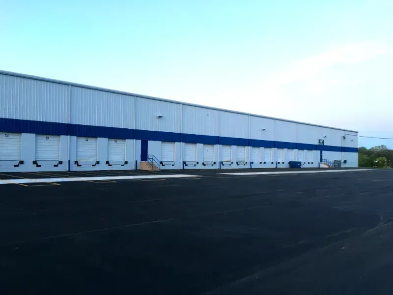 A large white and blue building with lots of loading doors