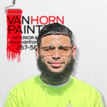 A man with glasses and a beard is wearing a van horn paint shirt