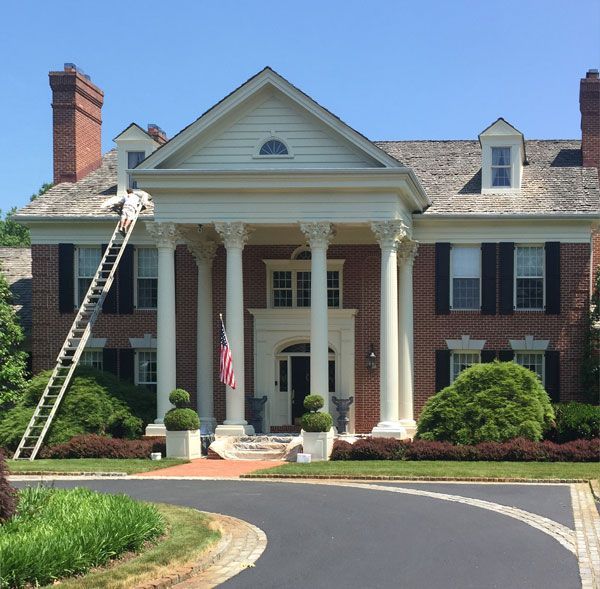 A large brick house with a ladder in front of it