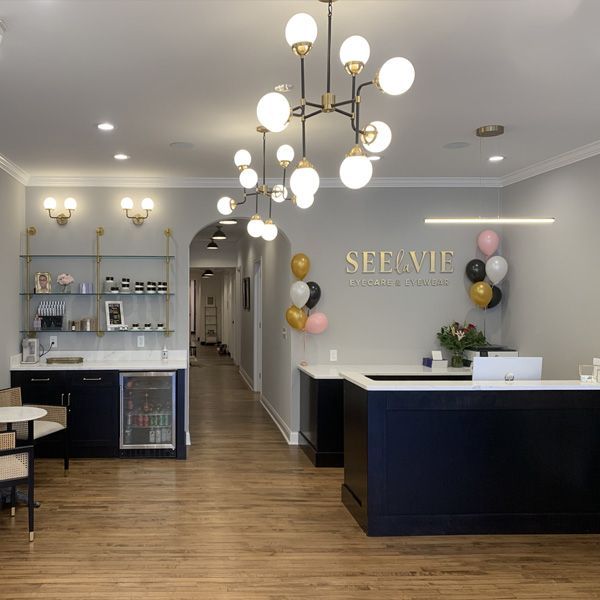 A reception area with balloons and a sign that says see vie