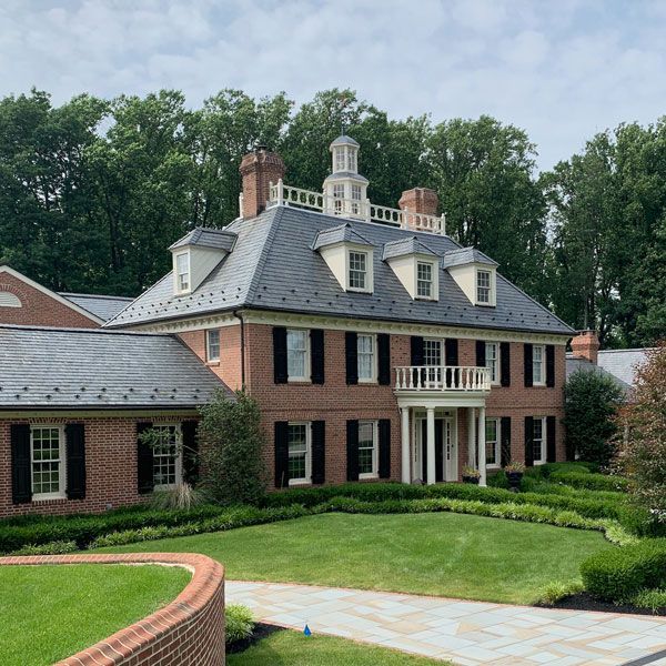 A large brick house with a slate roof and black shutters