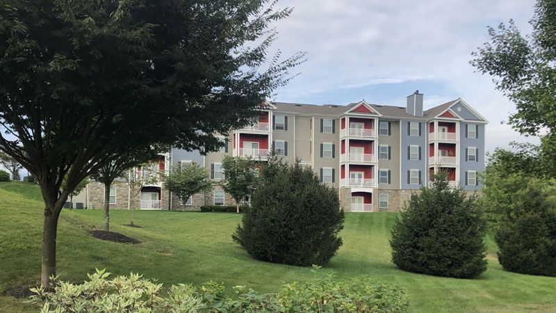 A large apartment building with trees in front of it