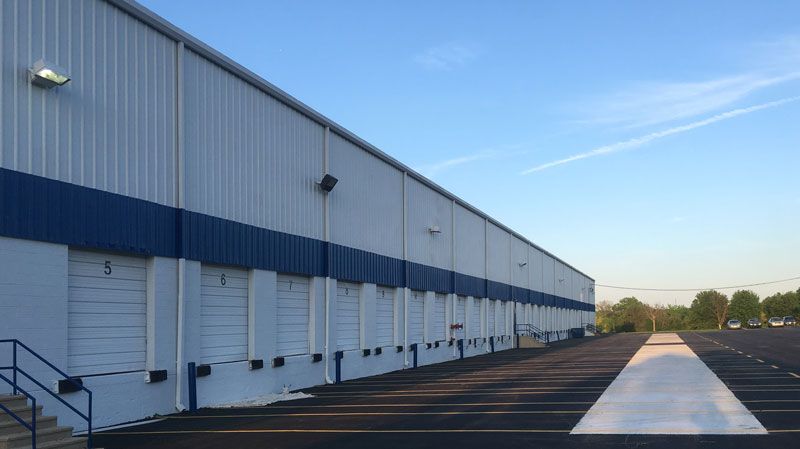 A large warehouse with a lot of loading doors and stairs.