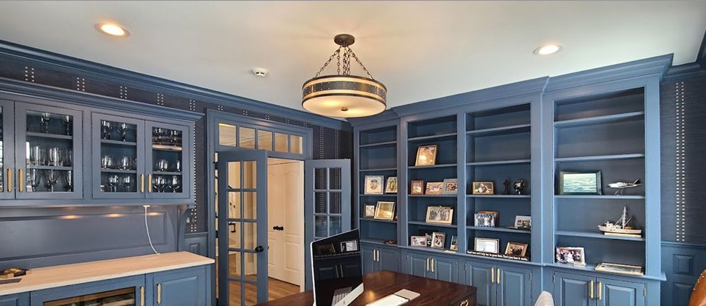 A kitchen with blue cabinets and shelves and a chandelier