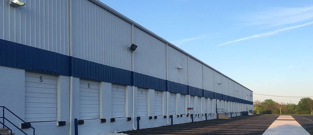 A large white and blue building with a lot of doors and stairs.