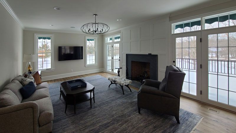 A living room with a fireplace , couch , chair and television.