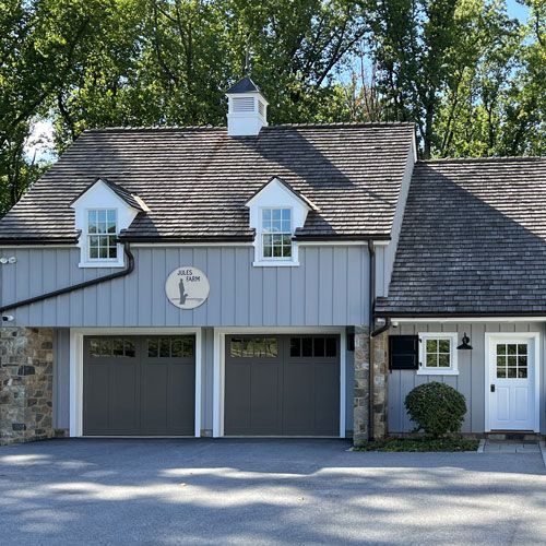 A house with two garage doors and a chimney on the roof