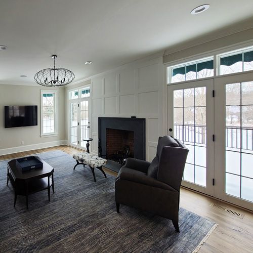 A living room with a fireplace , chair , table and television.