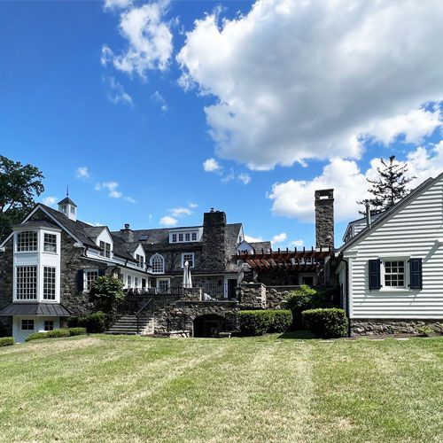 A large house with a chimney is surrounded by smaller houses