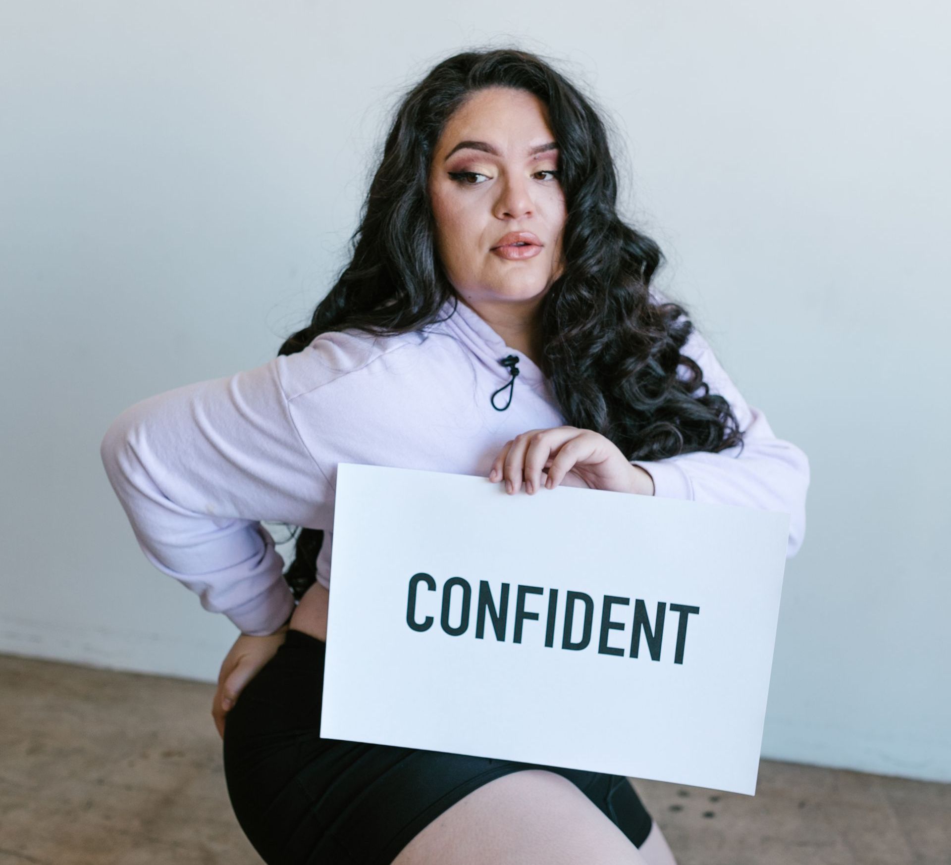 a woman is holding a sign that says confident