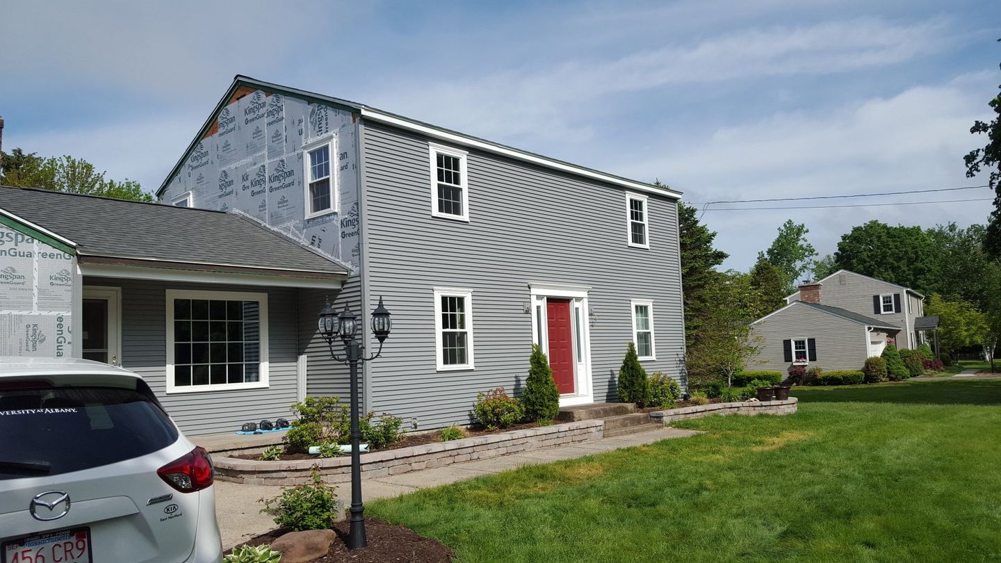 remodeling the exterior of this worn out home with fresh new grey siding and azek trim around the windows