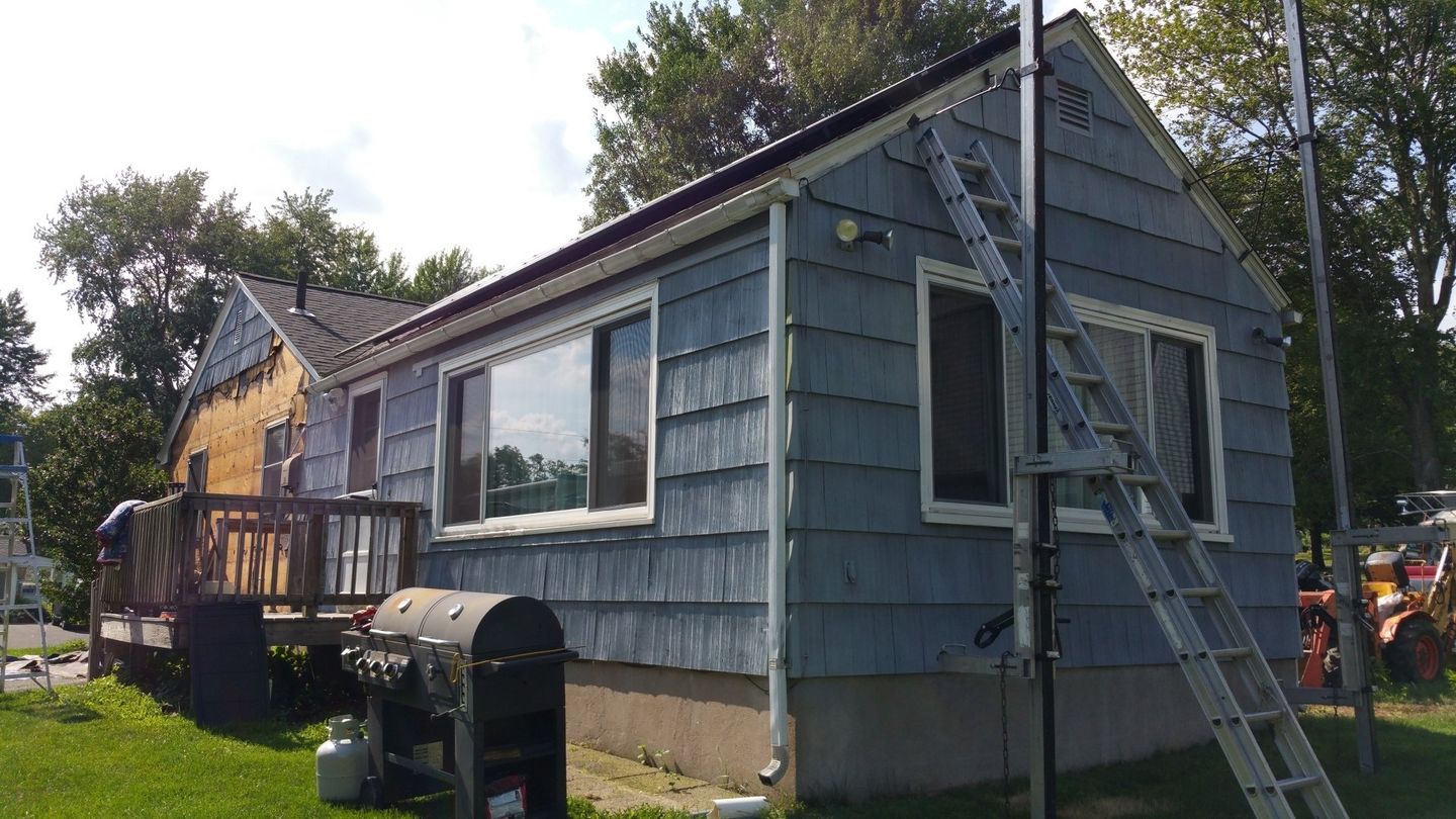 Wooden shake siding to be replaced is dried out, fading, and deteriorating altogether.