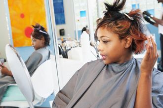 Young woman examining herself in the mirror at salon