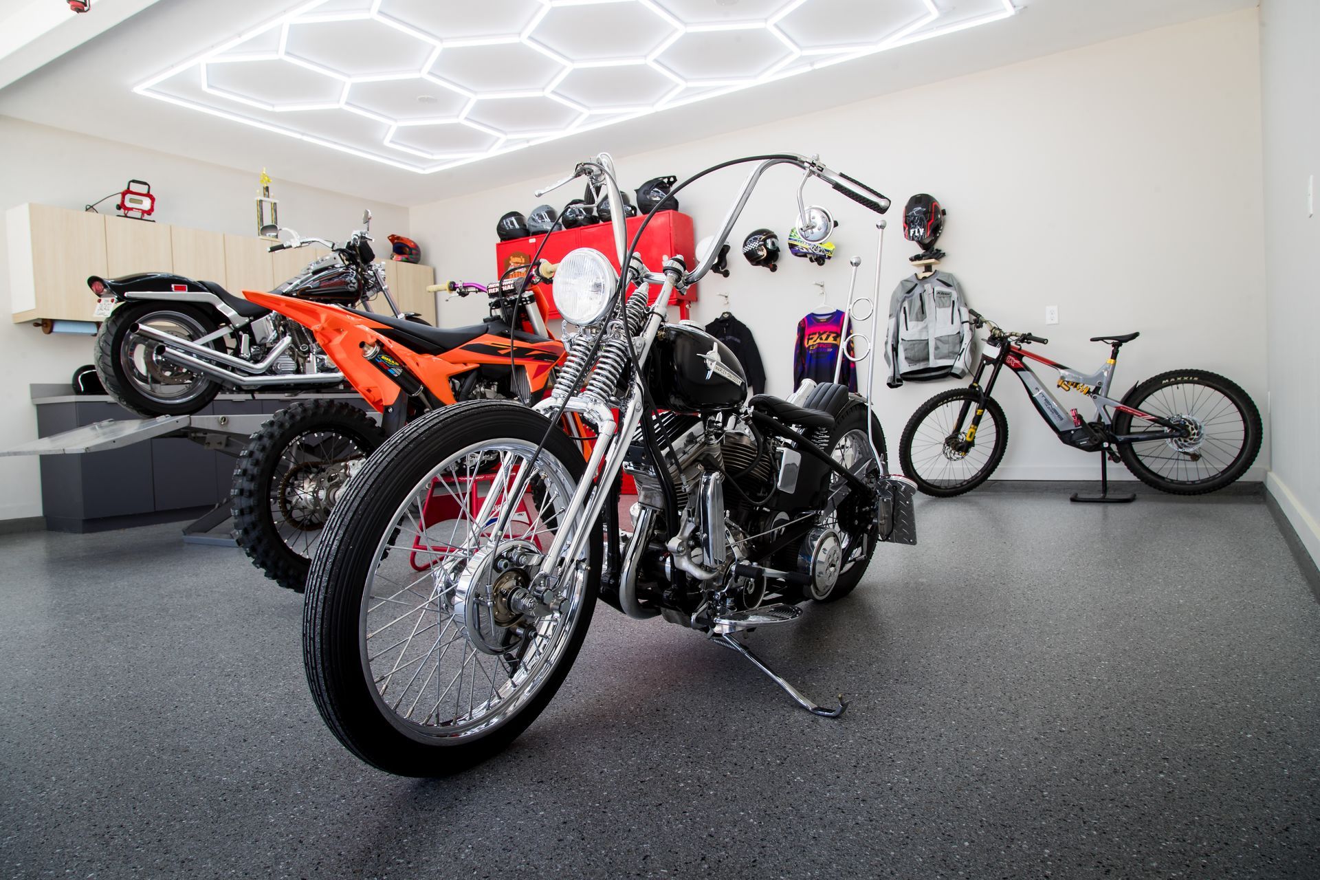 Motorcycles displayed in a modern showroom with bright hexagonal ceiling lights.