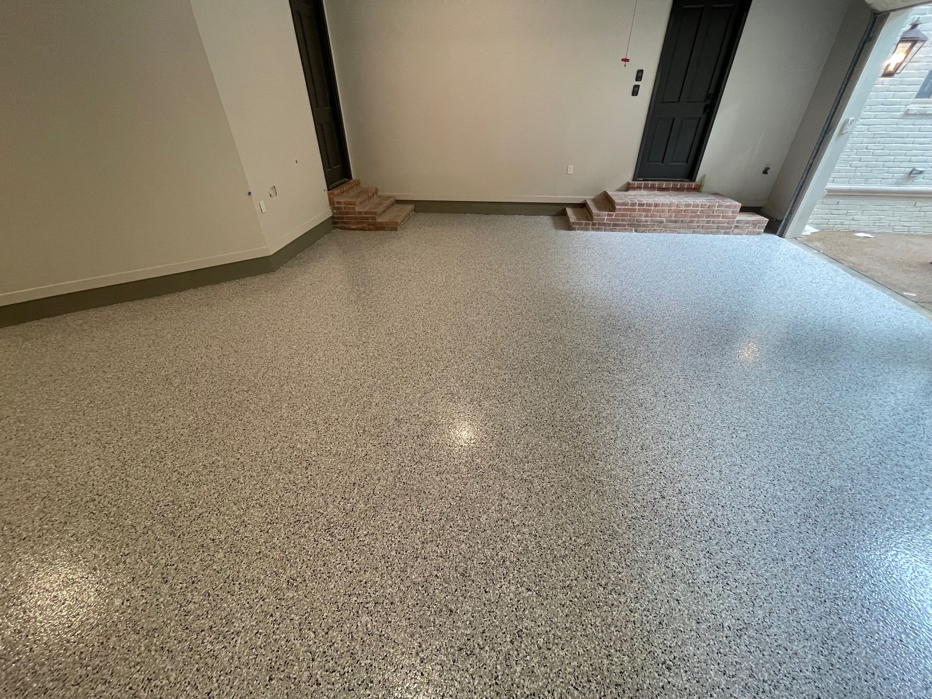 A room with a concrete floor and stairs in it.