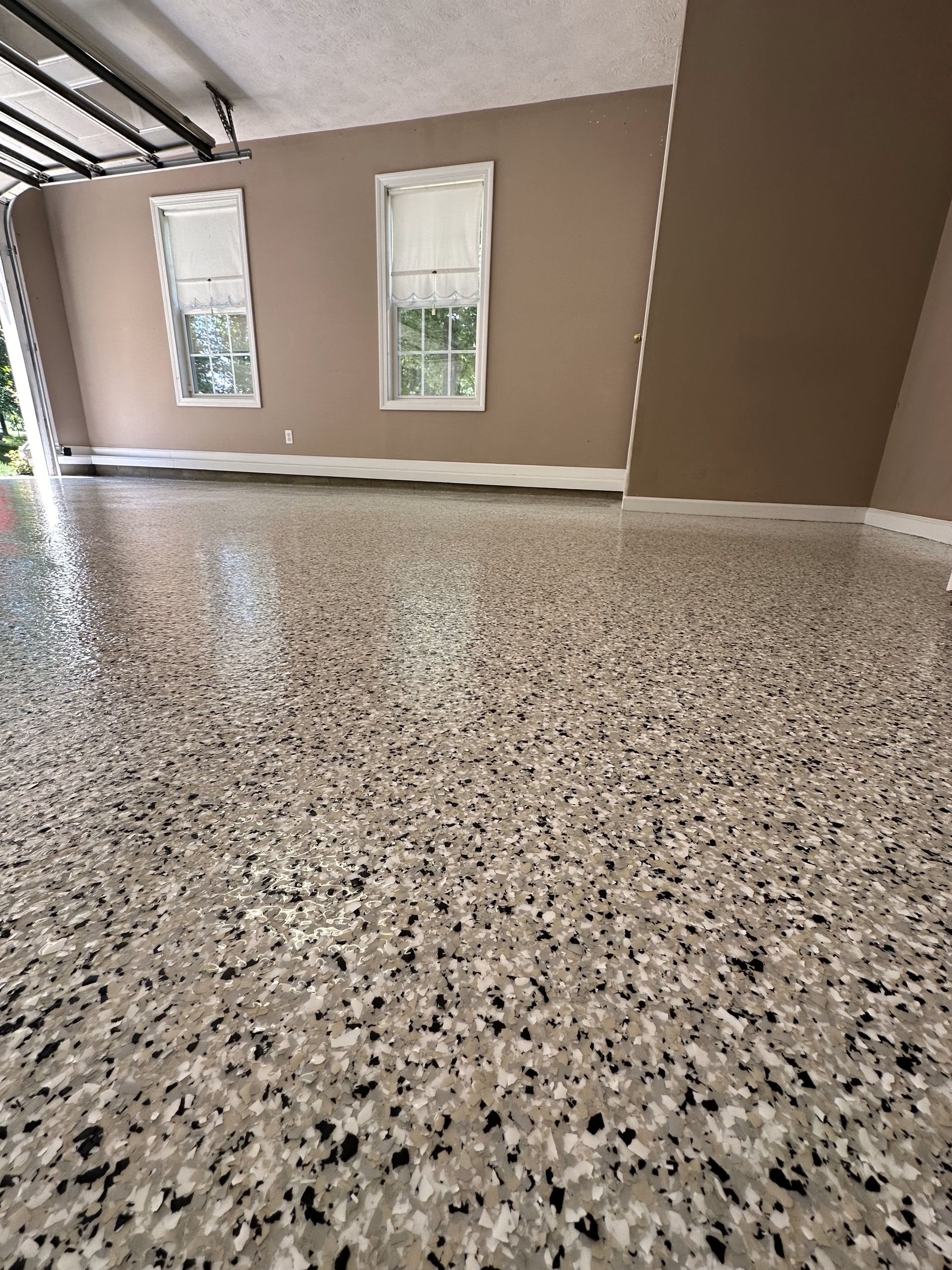 A garage with a concrete floor and two windows.