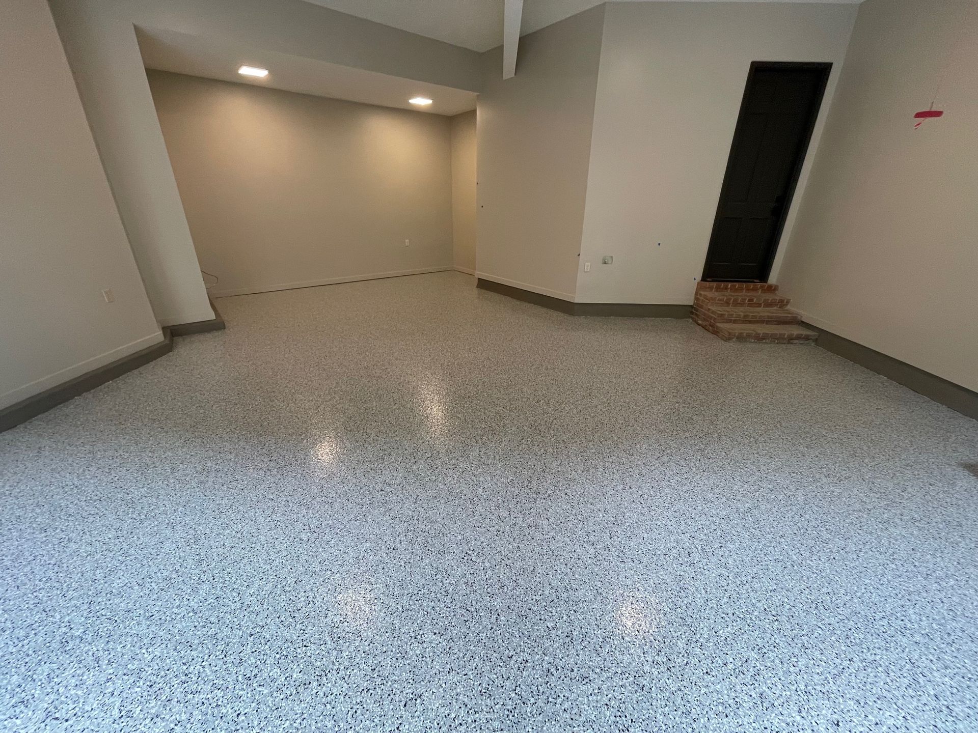 An empty room with a white floor and white walls.