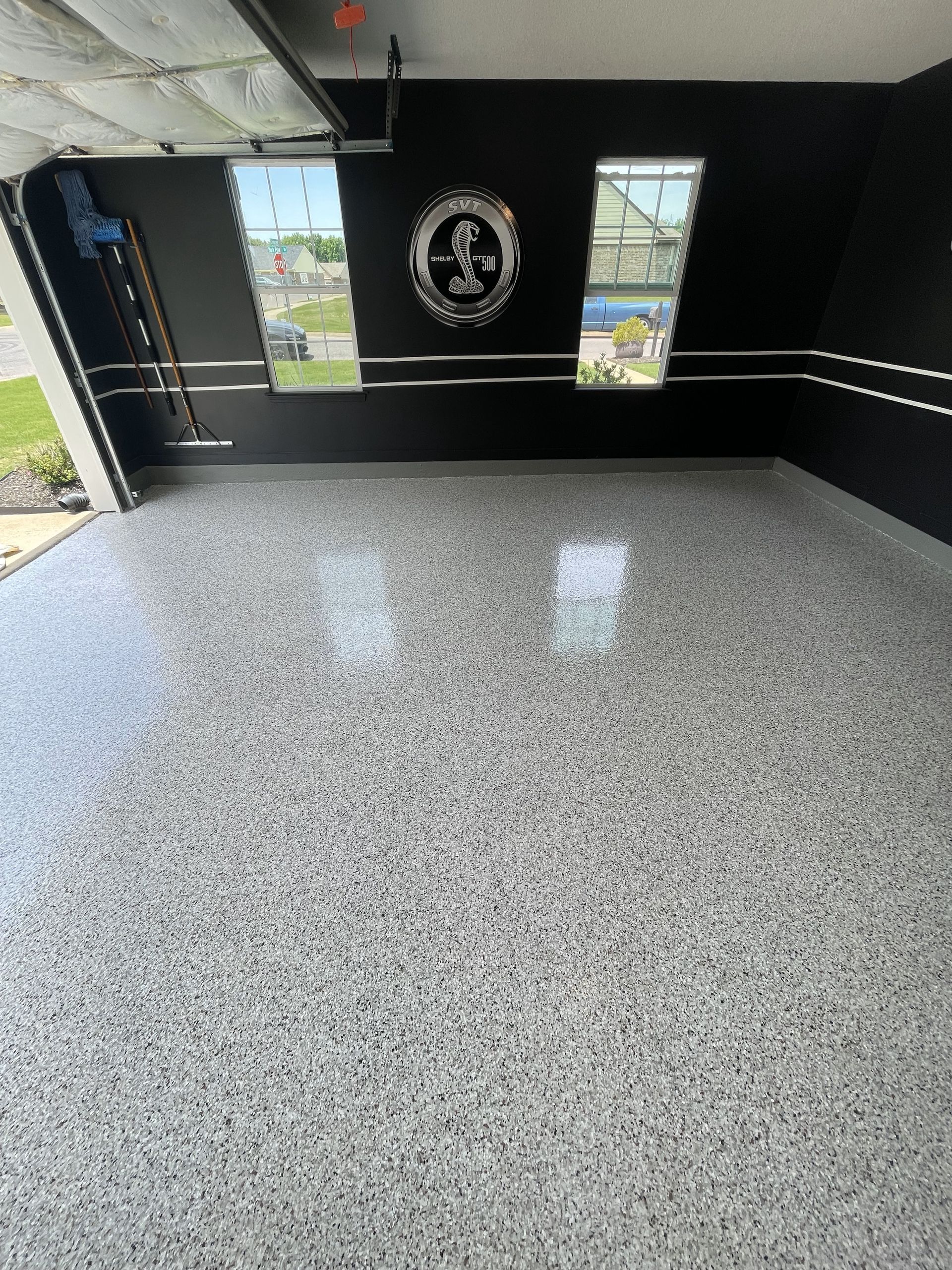 A garage with a gray floor and black walls.