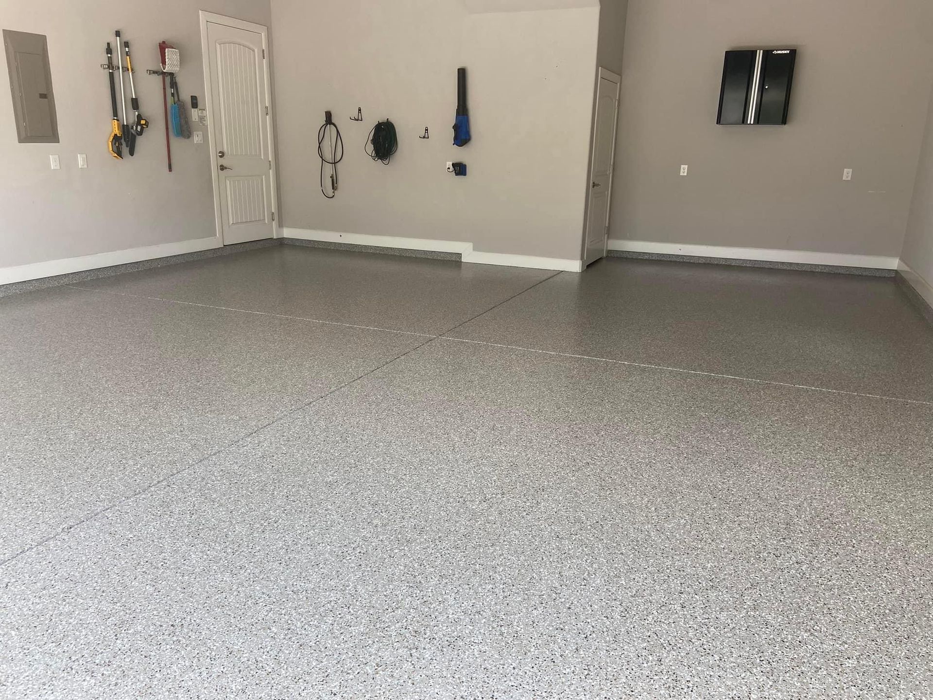 A garage with a gray floor and white walls.