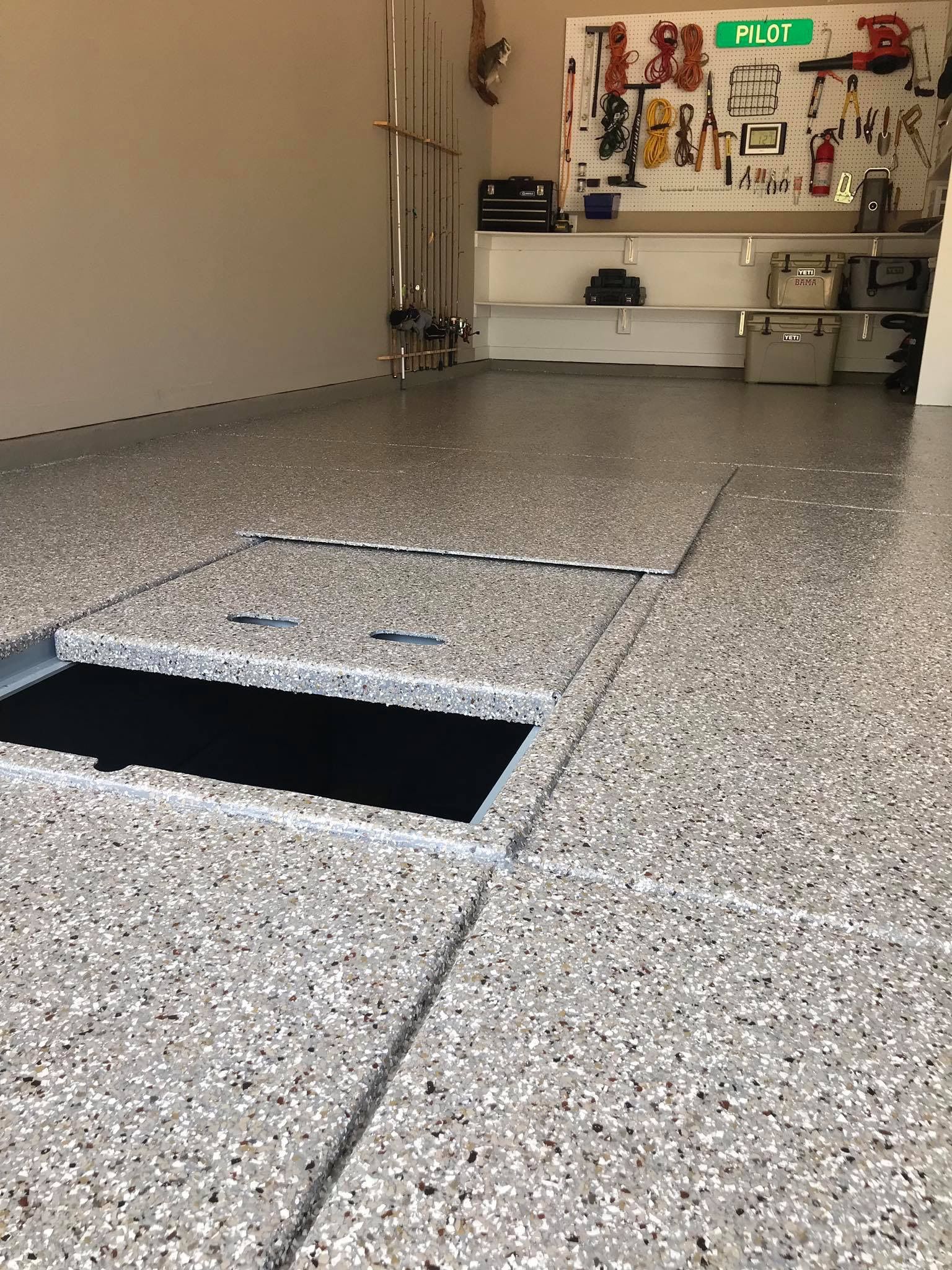 A garage with a concrete floor and a hole in the floor.