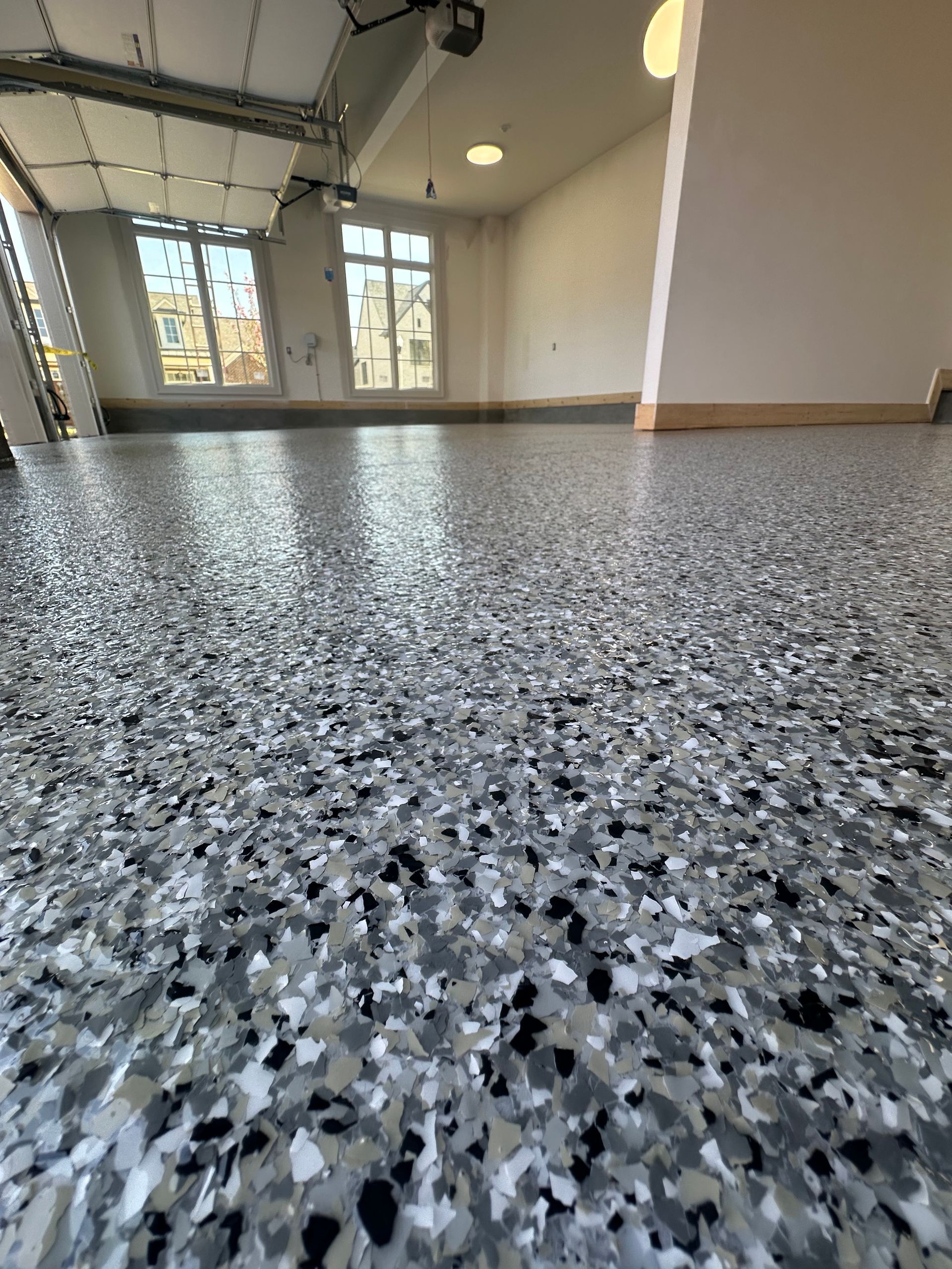 A close up of a garage floor with a garage door open.