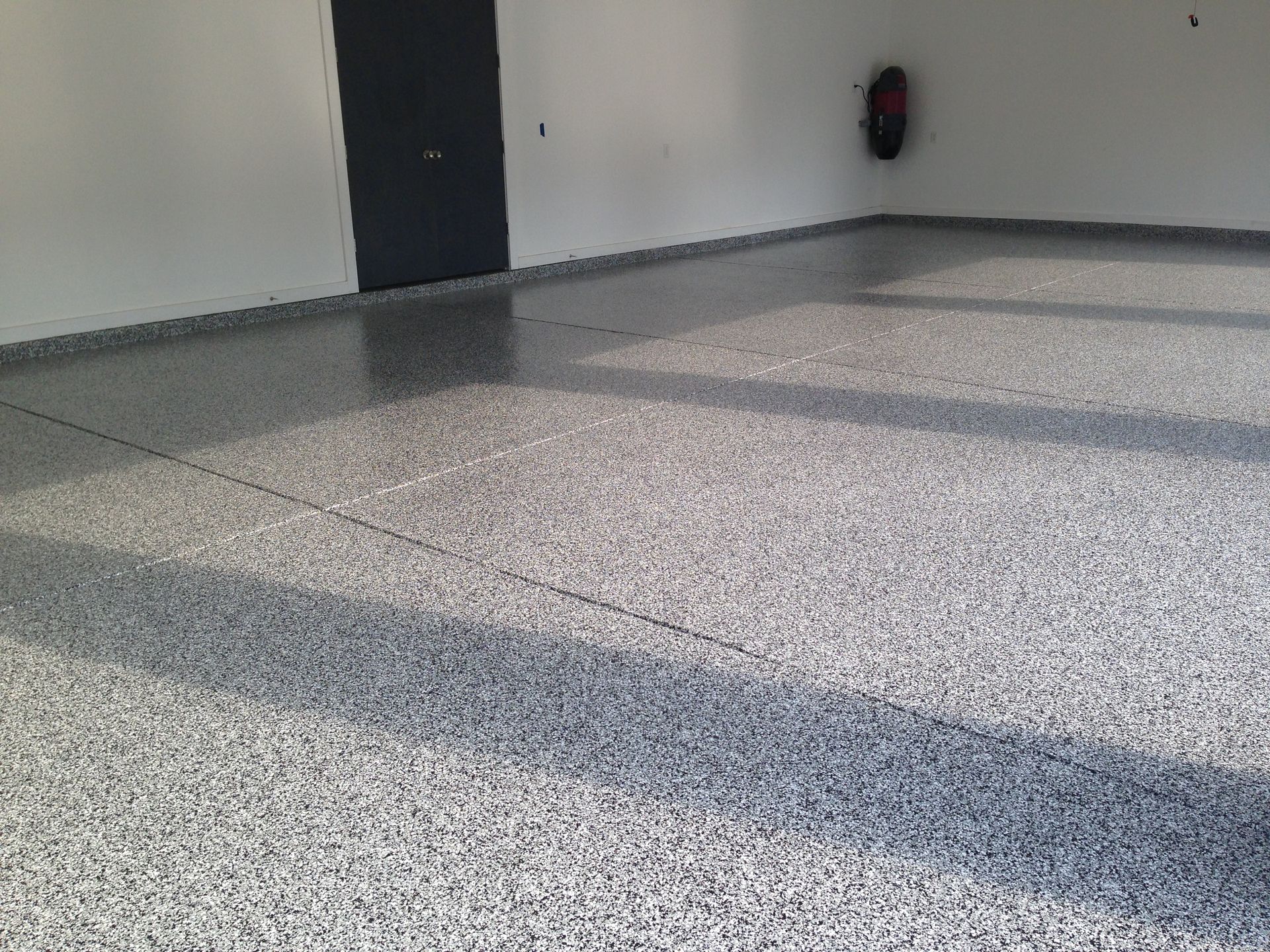 A garage with a gray floor and white walls.