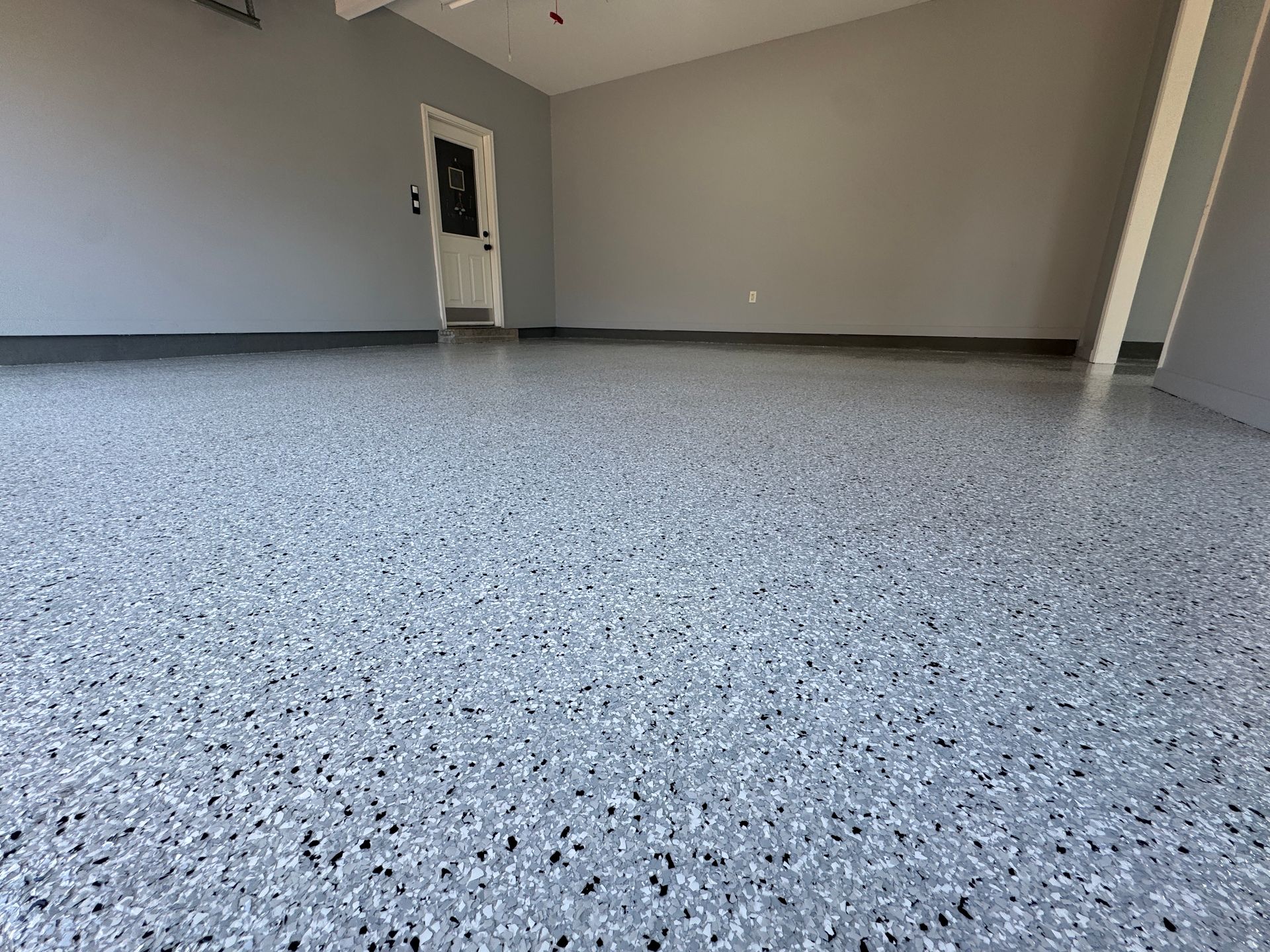 A garage with a gray floor and gray walls.
