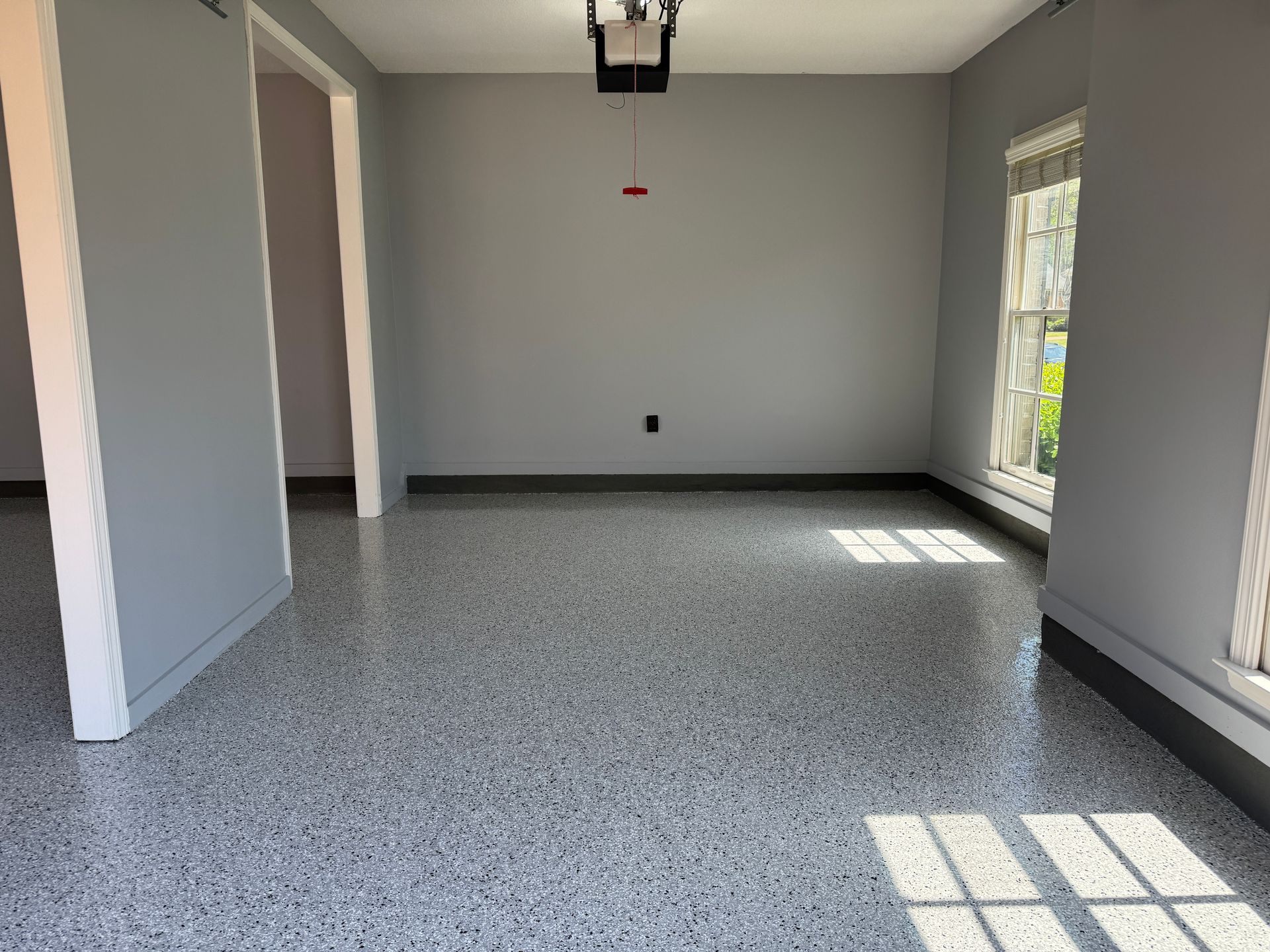 An empty room with a gray floor and gray walls.
