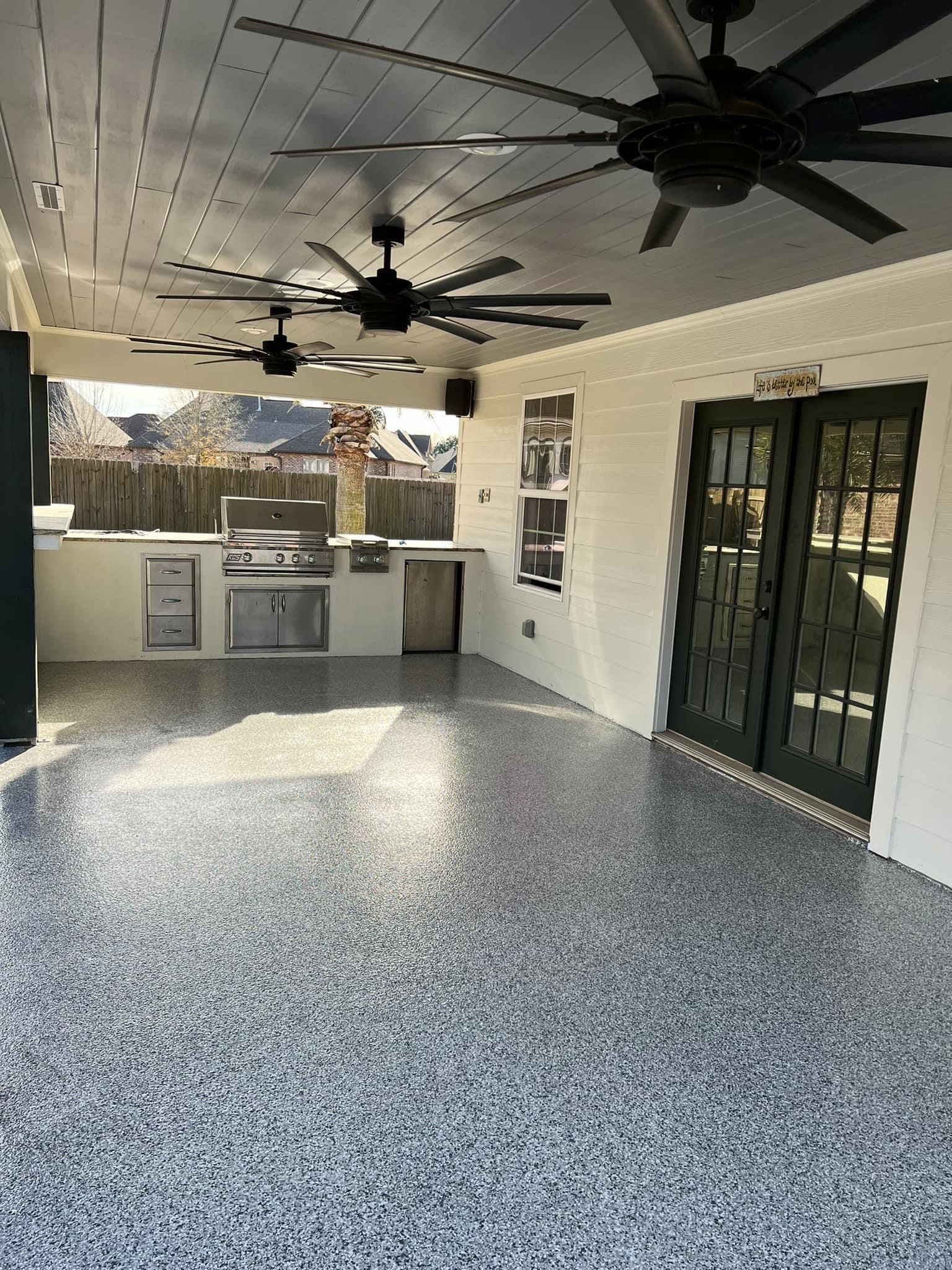 A large patio with a ceiling fan and sliding glass doors.