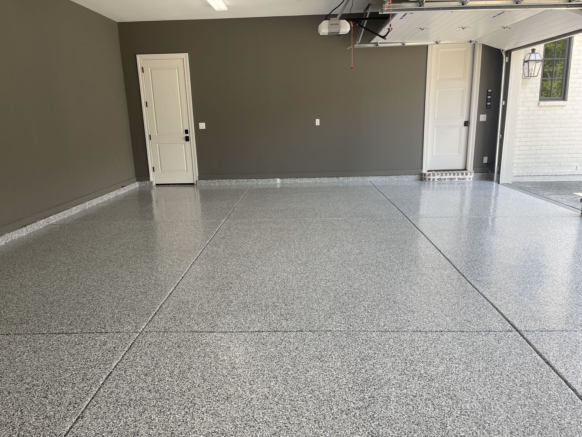 A garage with a gray floor and a white door.