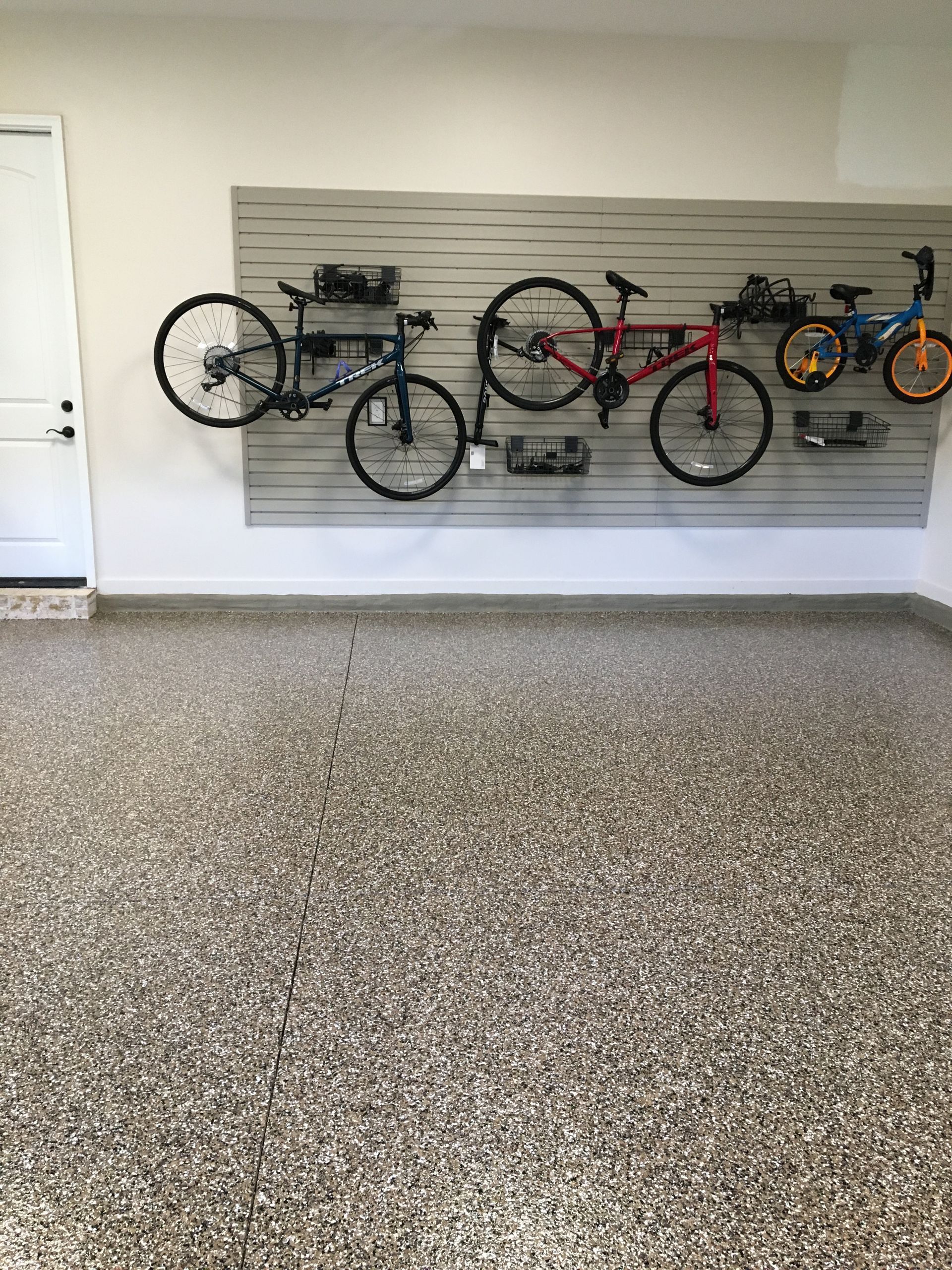 A row of bikes are hanging on a wall in a garage.