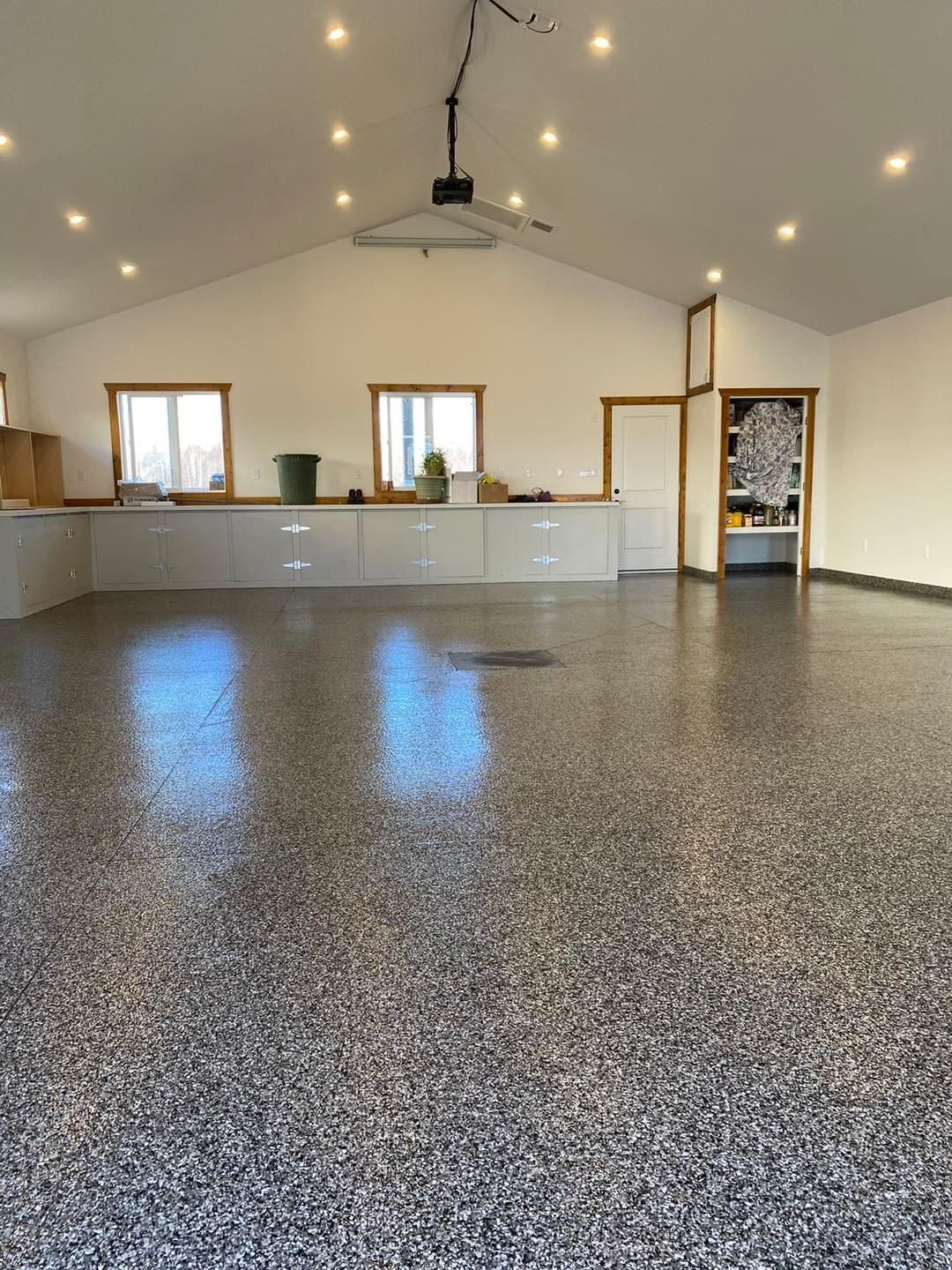 A large empty room with a gray floor and white walls.