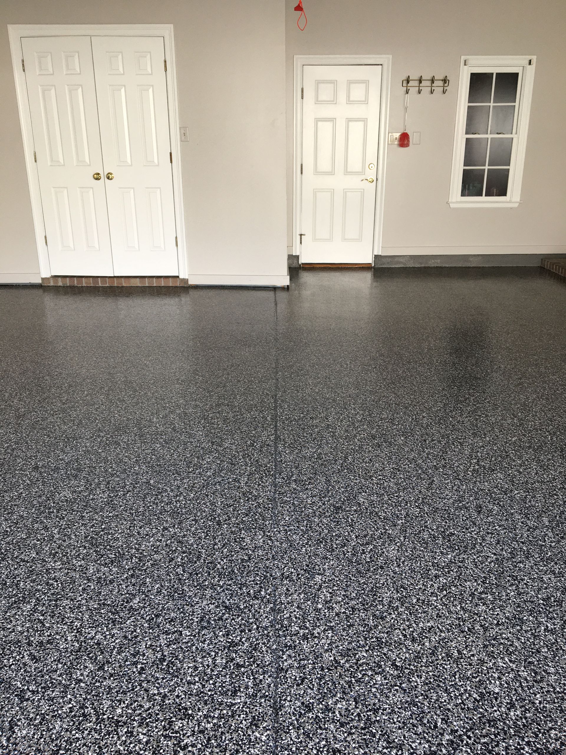 A garage with a gray floor and white doors.