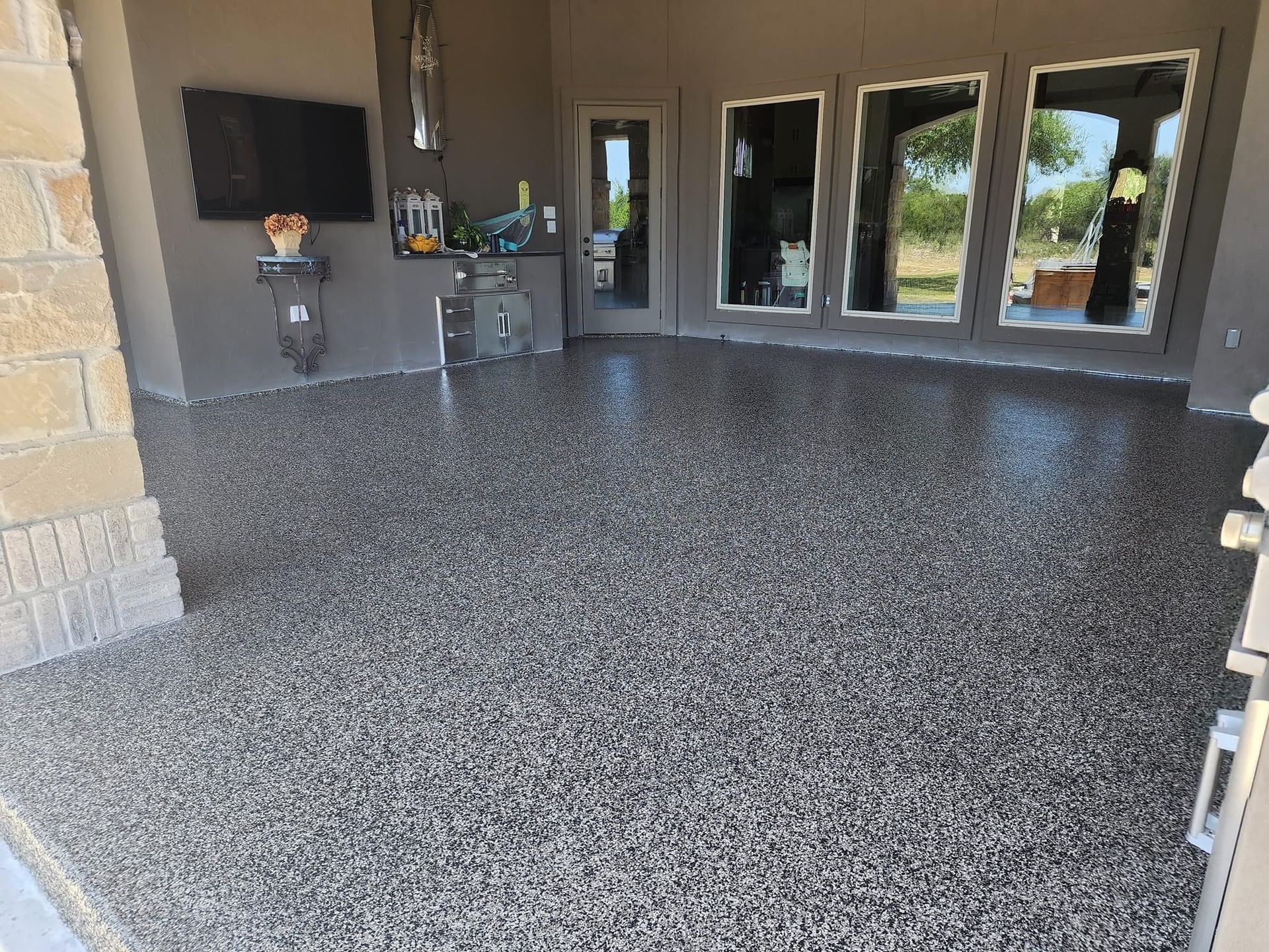 A large room with a concrete floor and a flat screen tv.