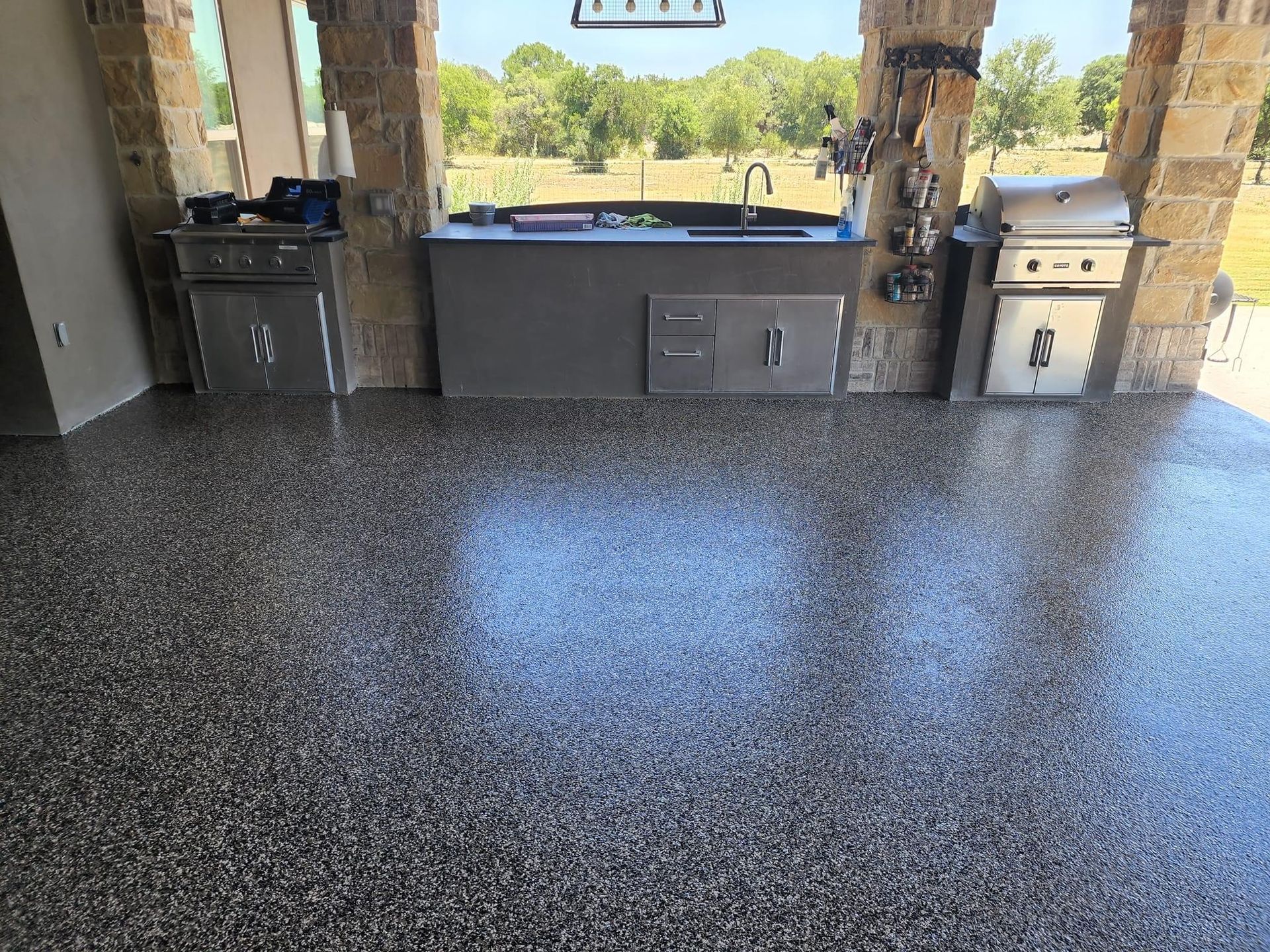 A kitchen with a concrete floor and a grill.