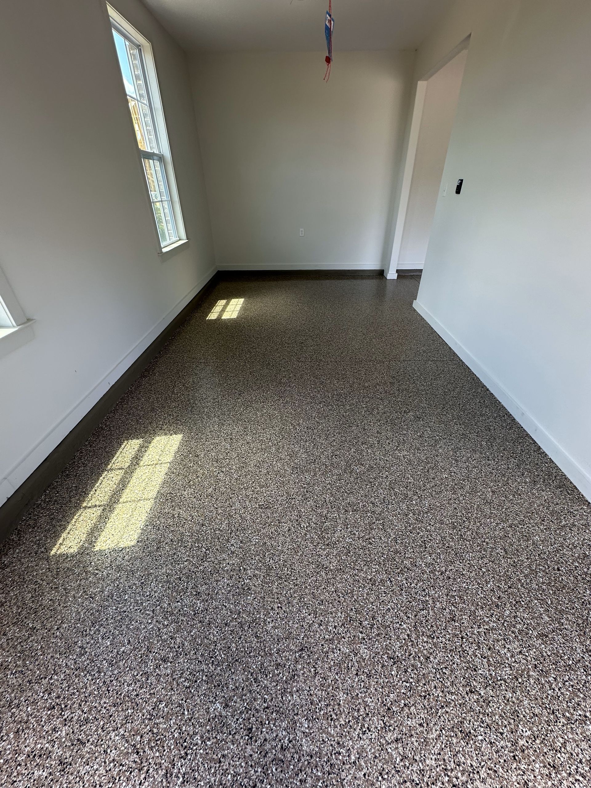 A room with a carpeted floor and a window.