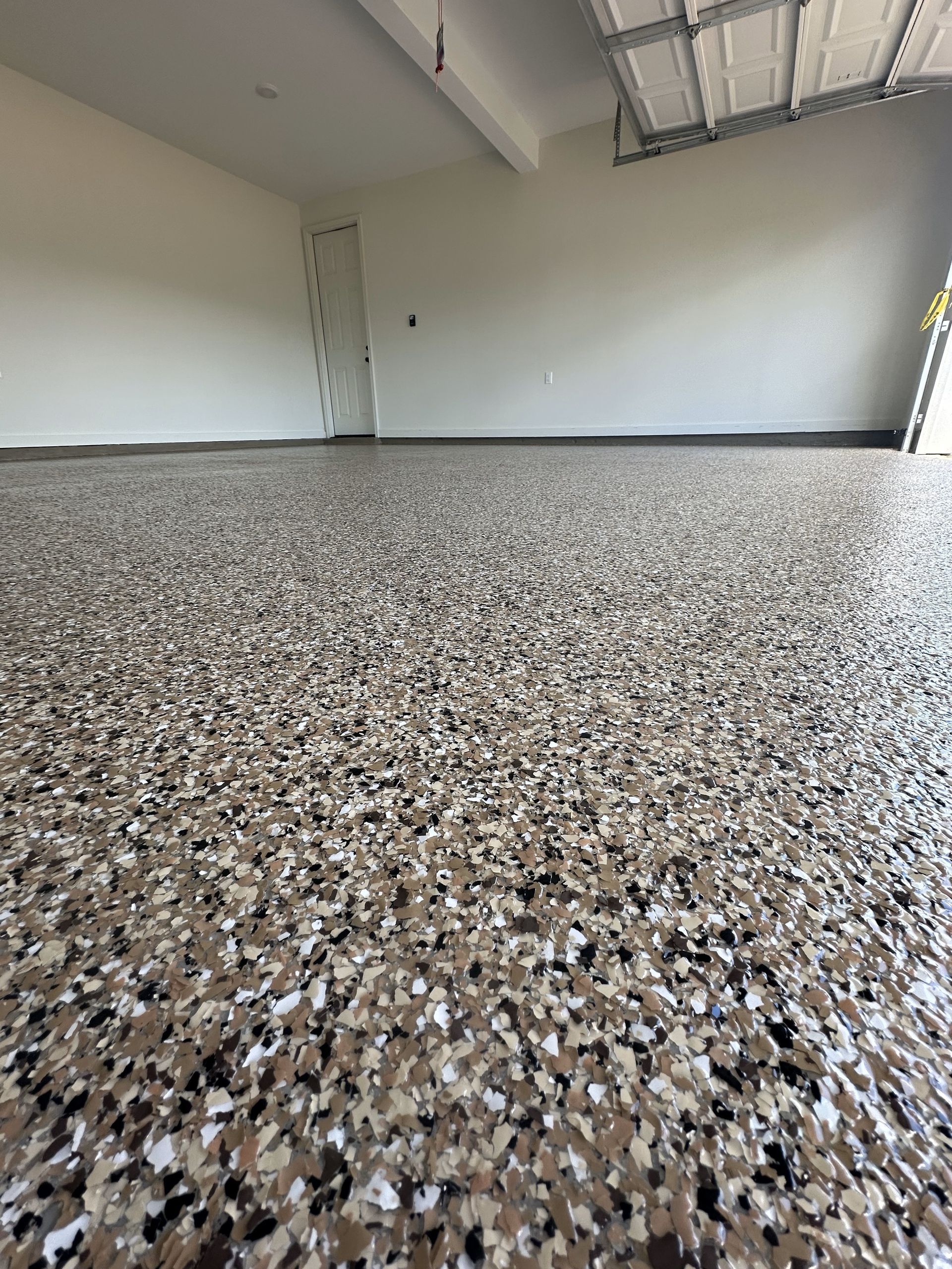 A garage with a camouflage floor and a garage door.