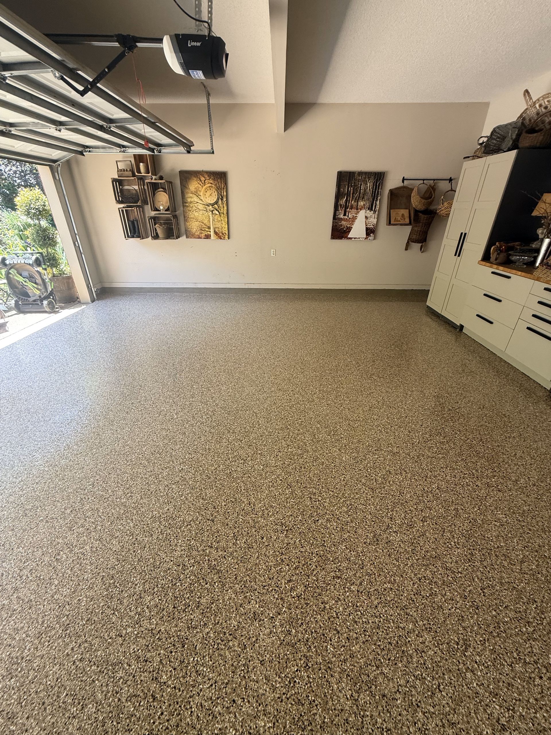 A garage with a garage door open and a painting on the wall.