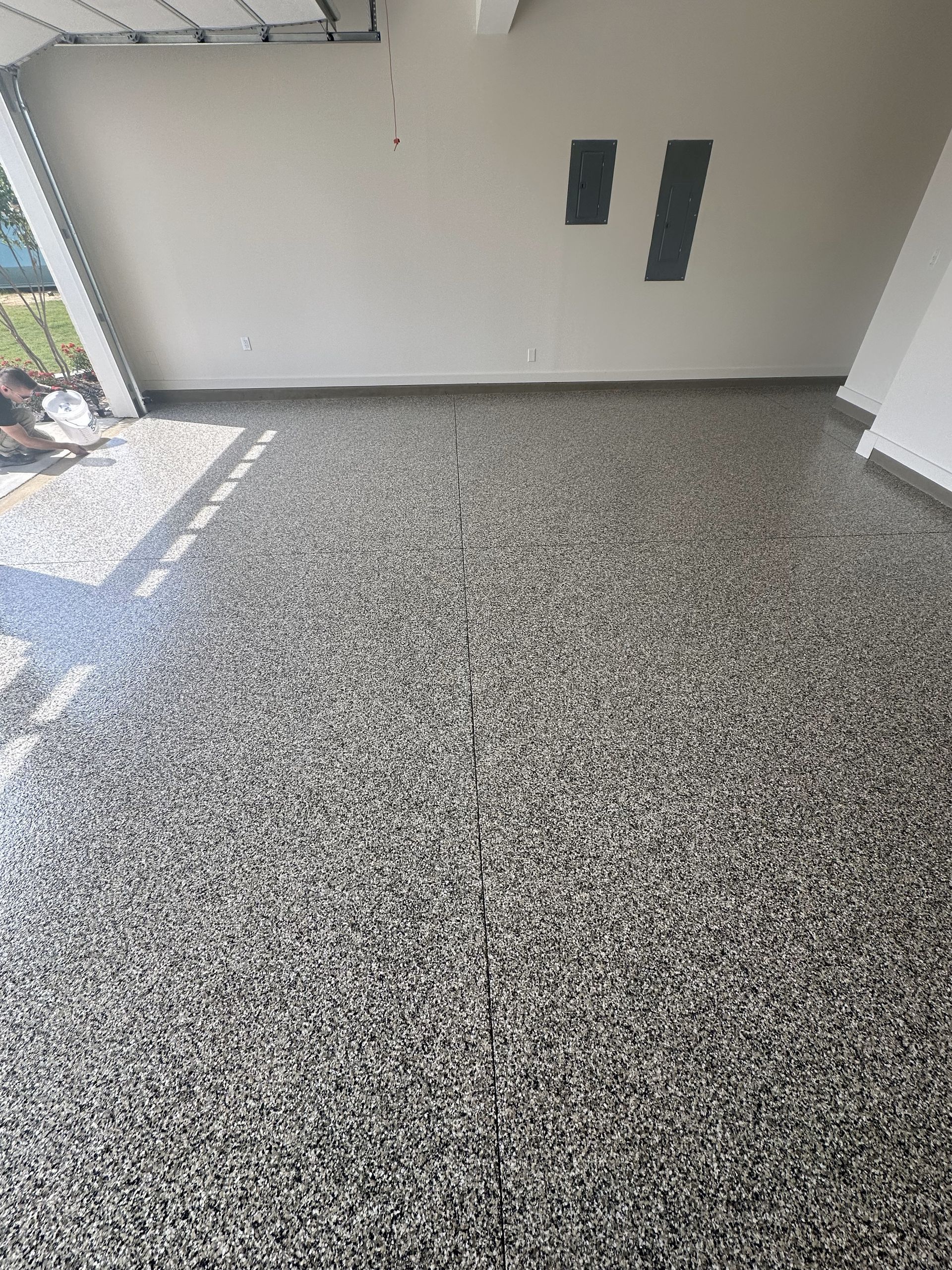 A garage with a concrete floor and a white wall.