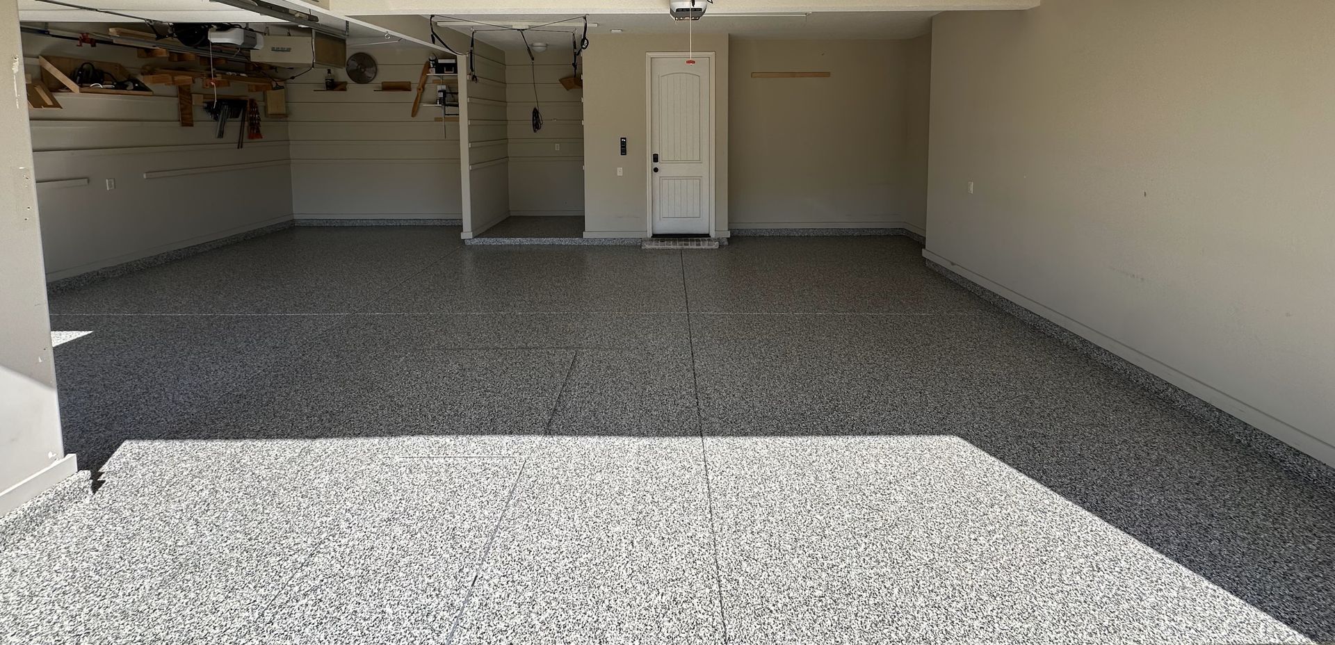 An empty garage with a gray floor and white walls.