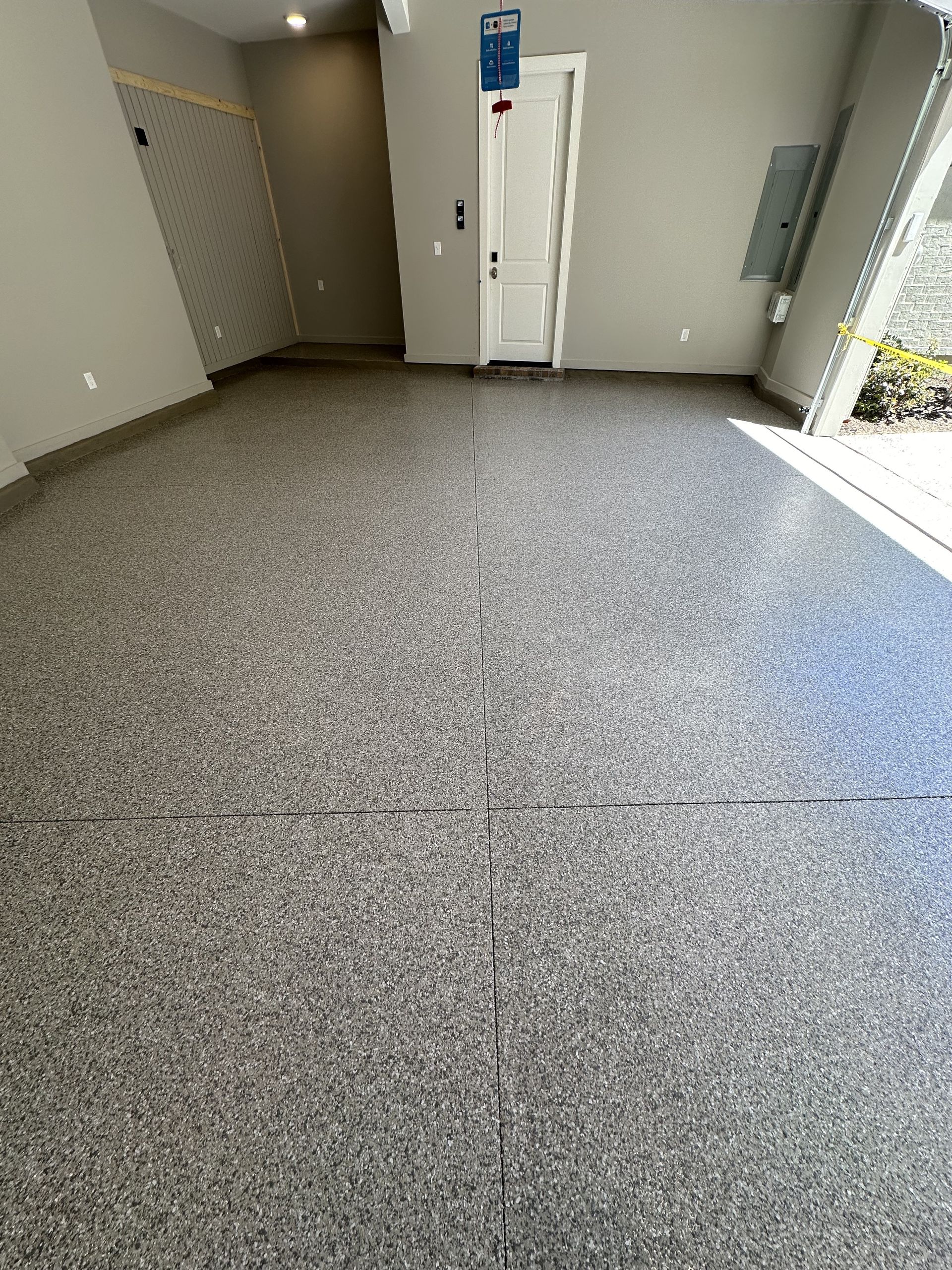 A garage with a gray floor and a white door.