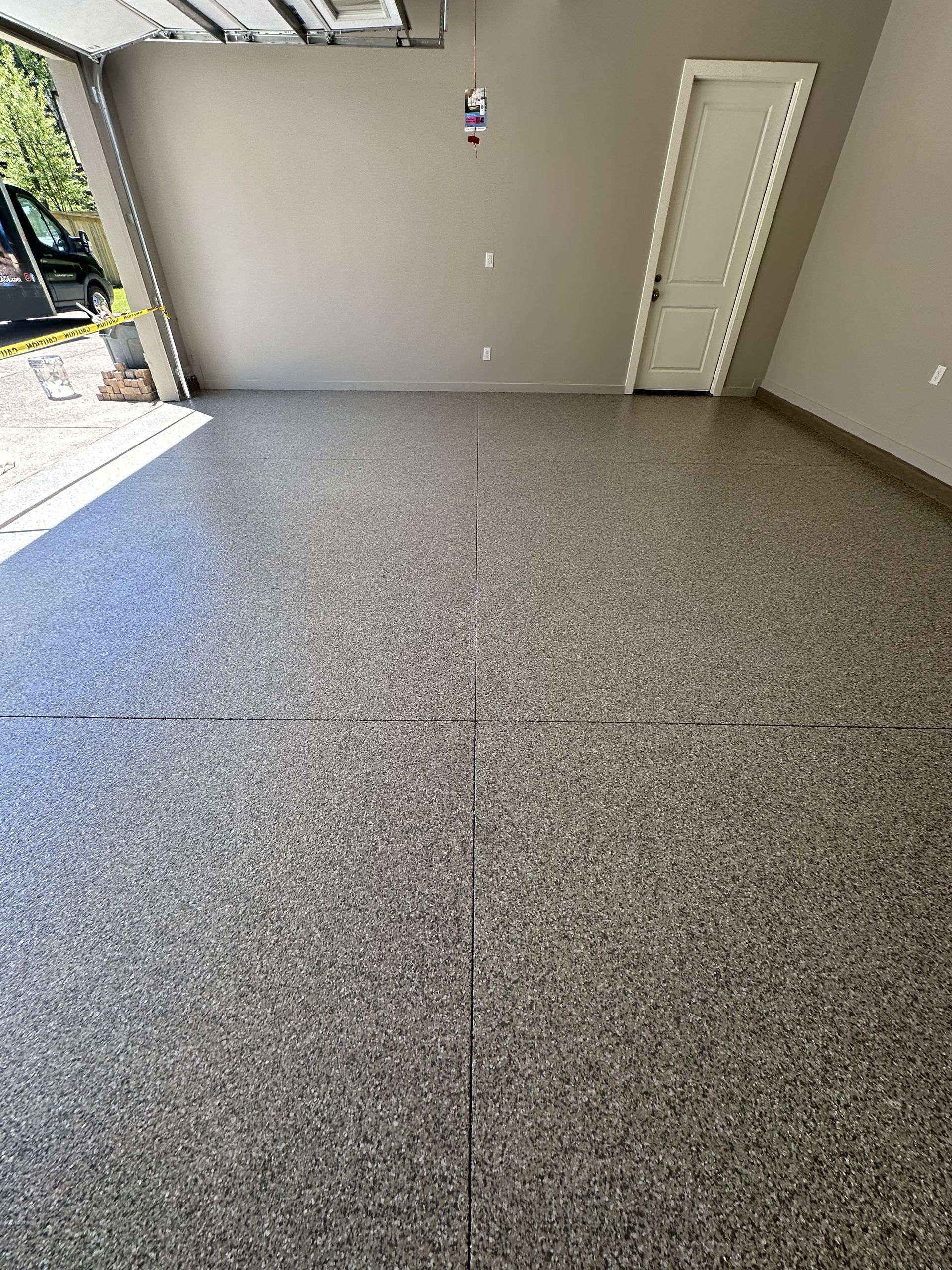 A garage with a gray floor and a white door.