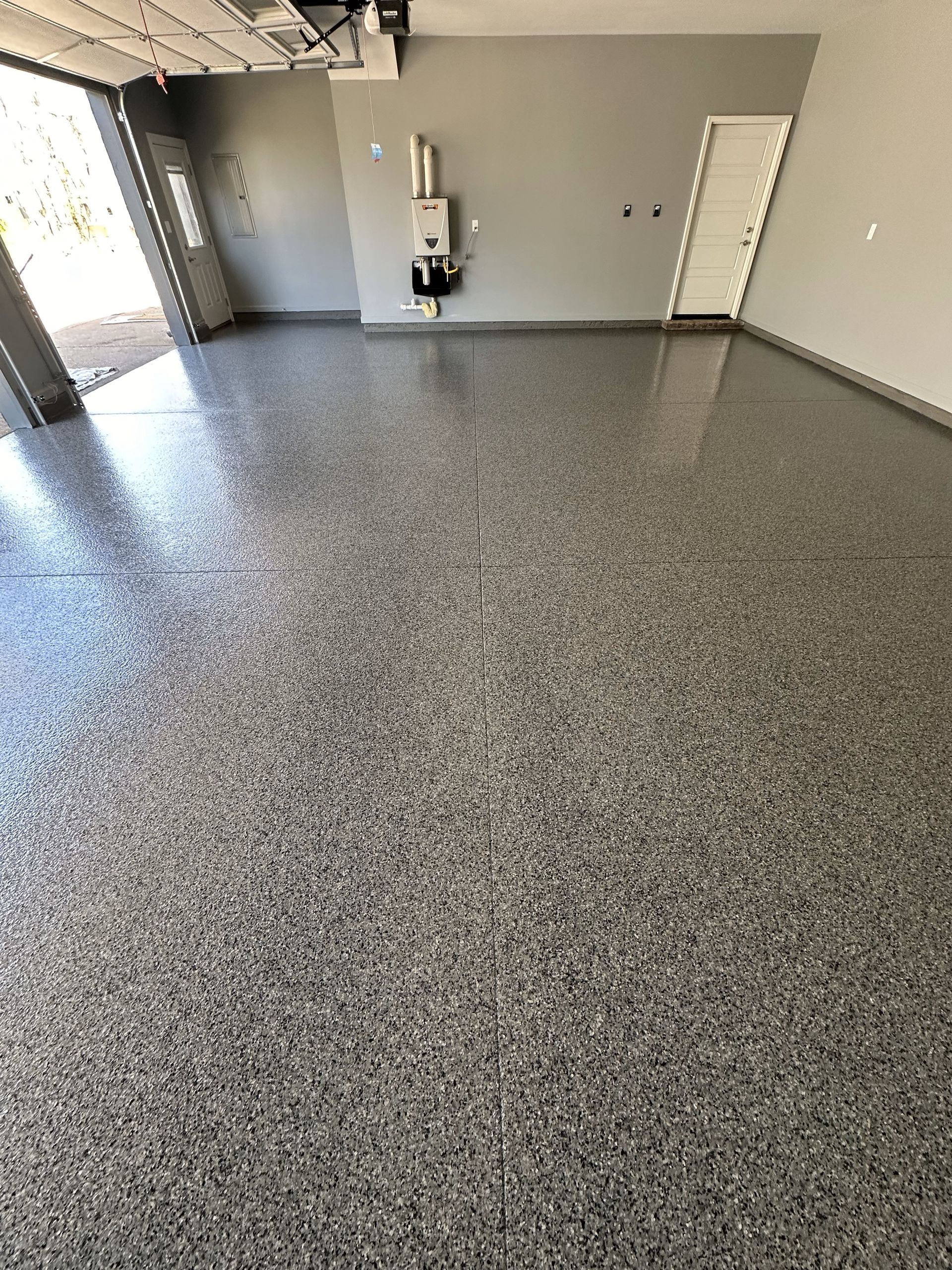 A garage with a gray floor and a white door.
