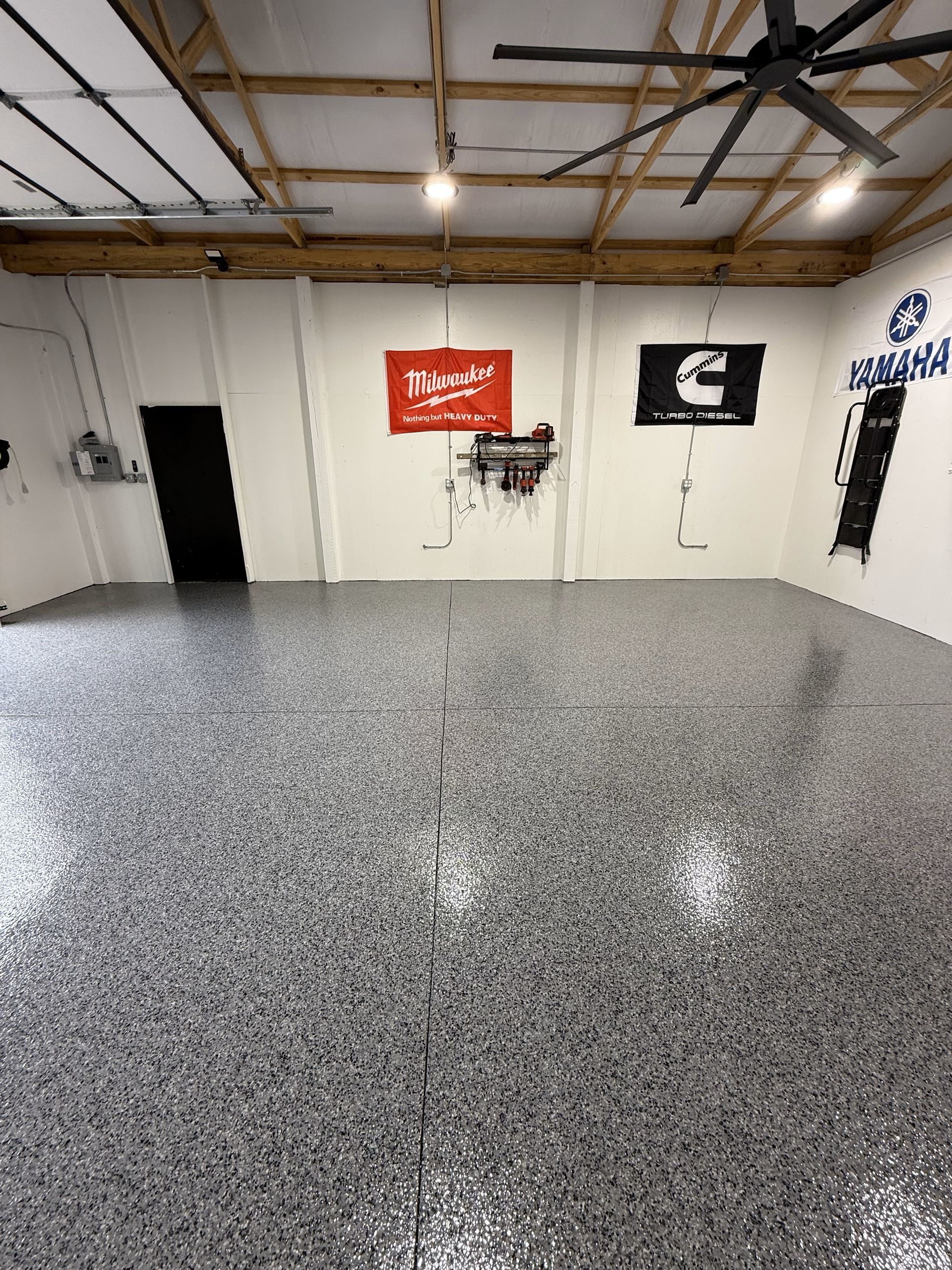 A large room with a ceiling fan and a sign on the wall that says yamaha