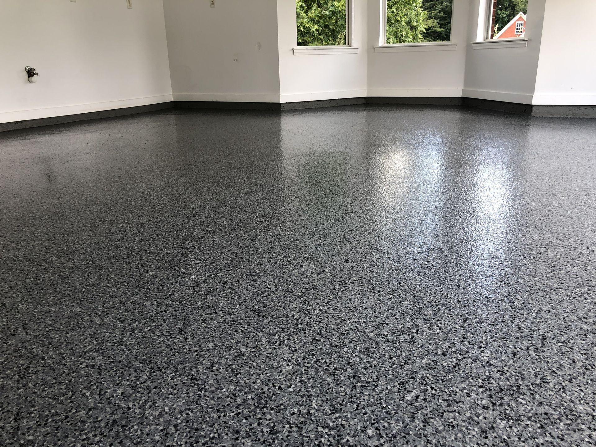 A garage with a gray concrete floor and white walls.
