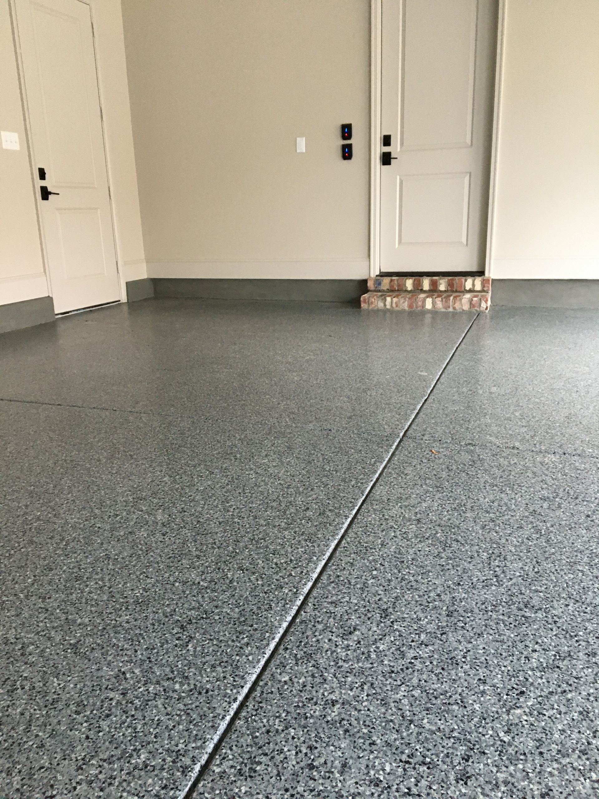 A garage with a gray floor and white doors.