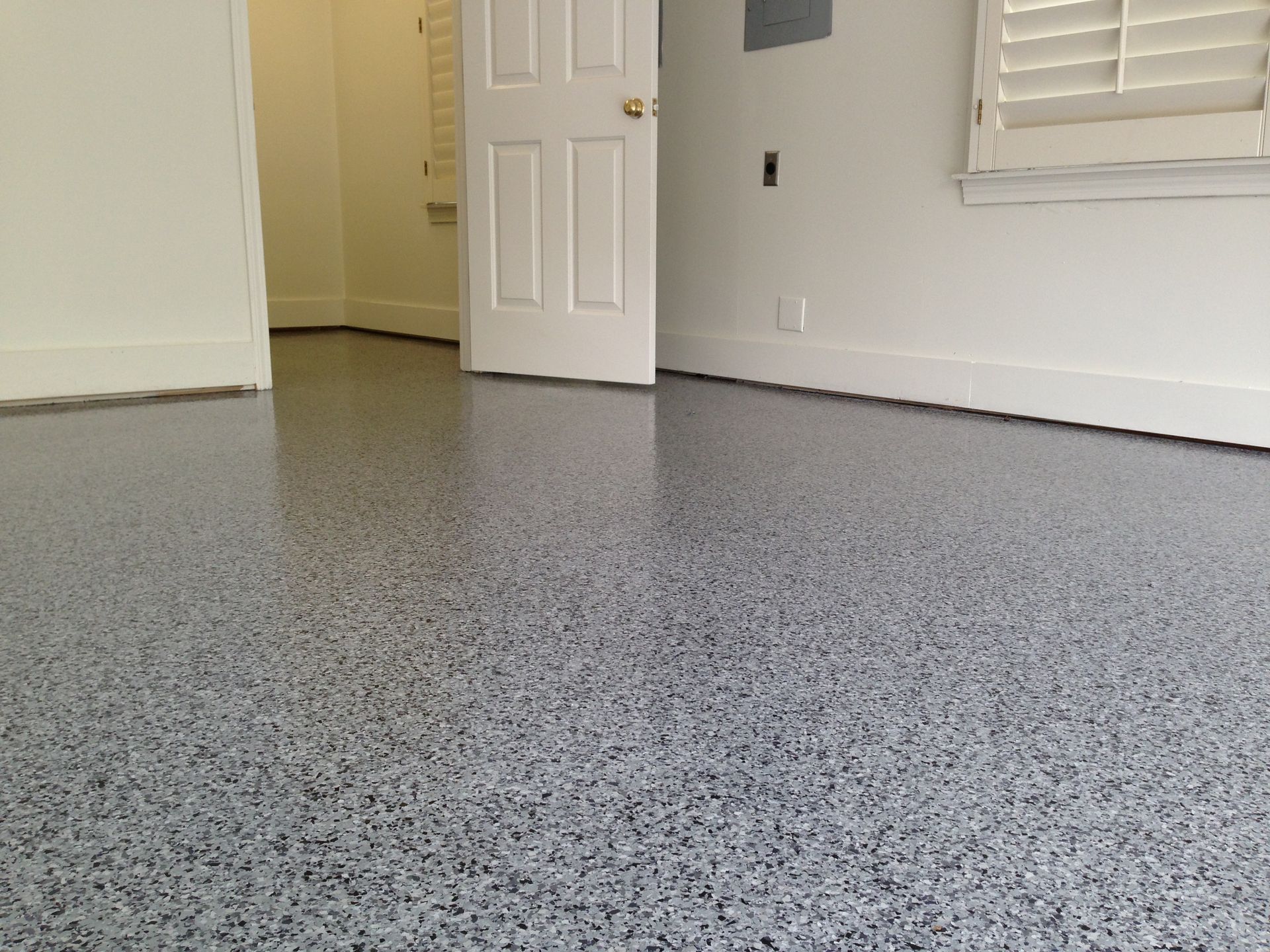 A room with a gray floor and a white door