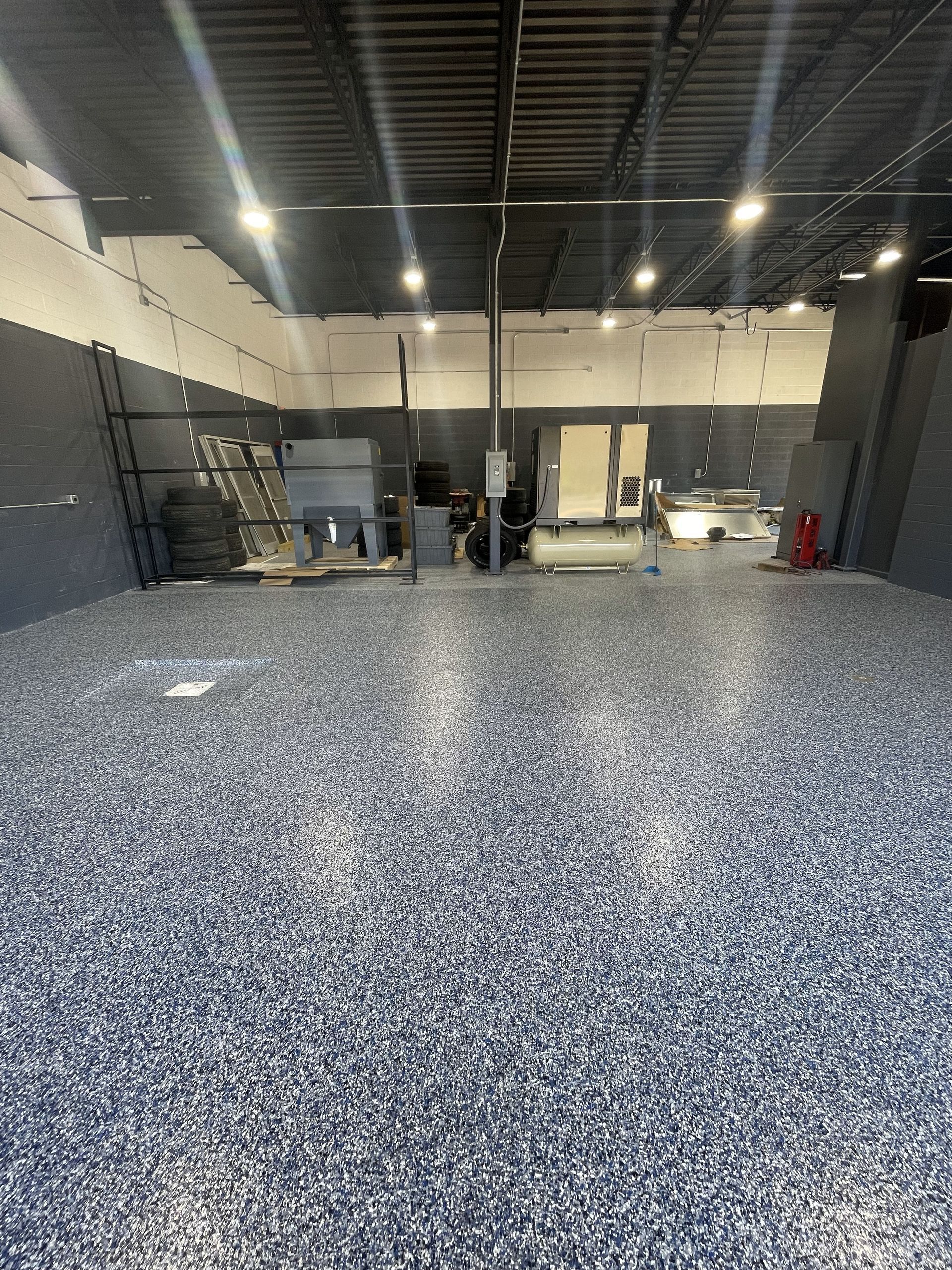 A large warehouse with a lot of gravel on the floor.